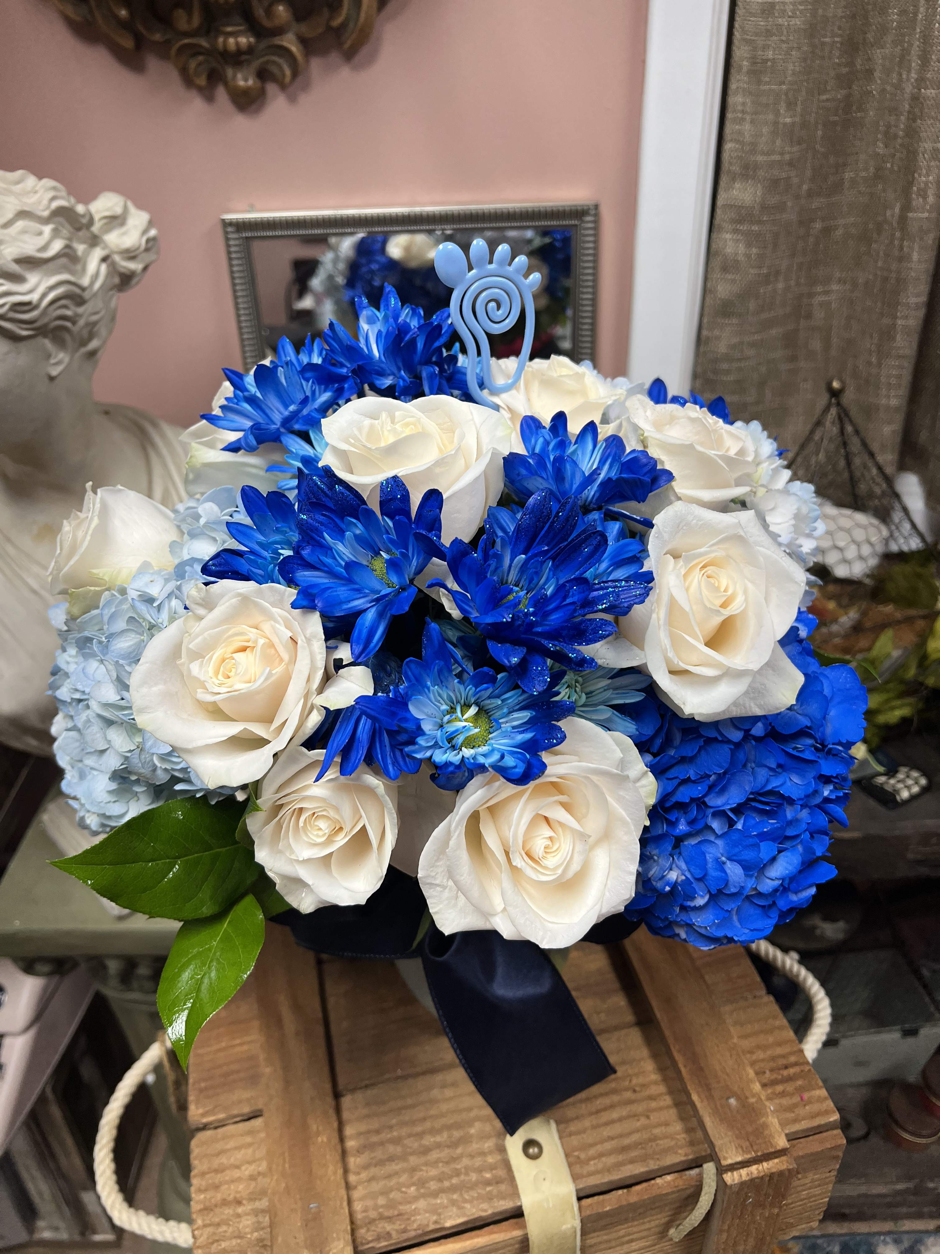 Blue and white bouquet of roses, hydrangeas, and daisies with a ribbon