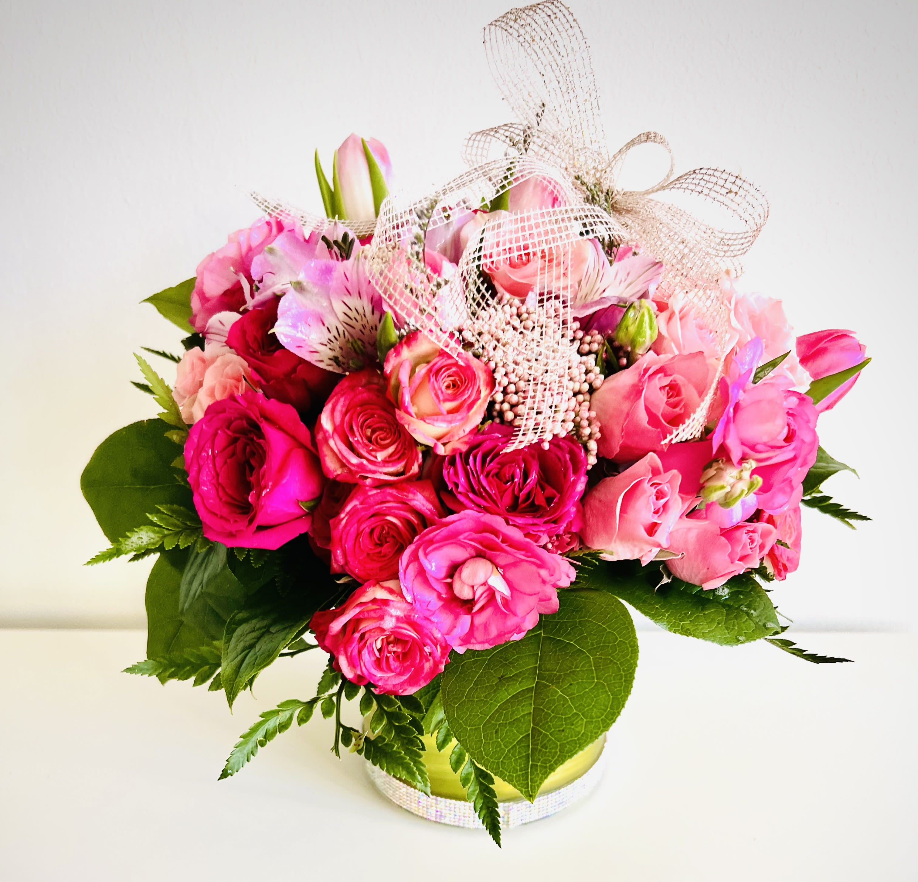 Petal kiss - Blushing blooms in every shade of pink come together for a soft, romantic display. This charming arrangement radiates warmth, joy, and elegance—perfect for any heartfelt occasion. A beautiful way to say “You’re loved” with the timeless grace of pink flowers. For same day delivery and Free Delivery Options Text or Call  832-973-1376.