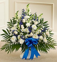 White and blue funeral spray with a blue ribbon