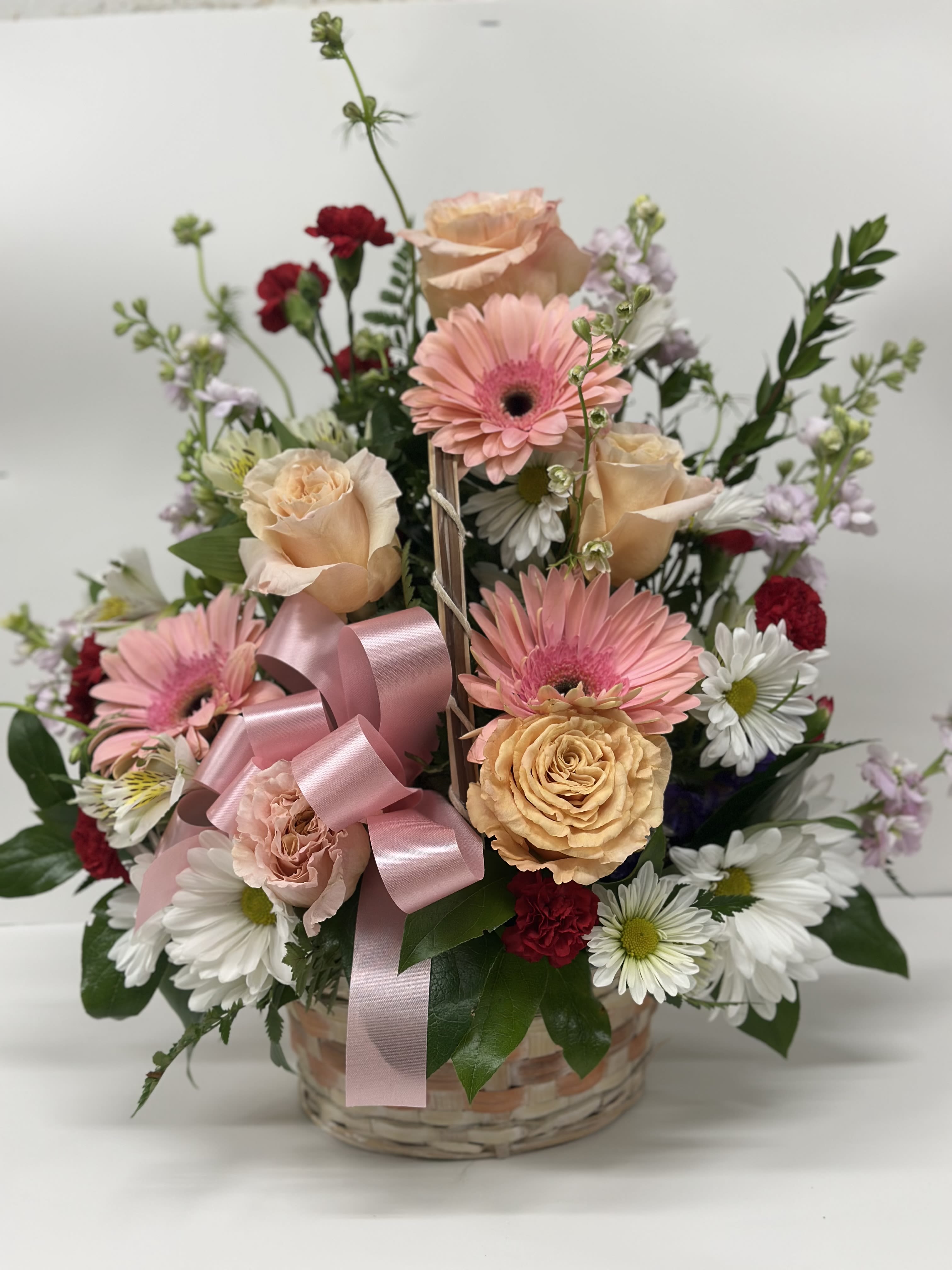Mixed pink and white flower basket with a pink ribbon