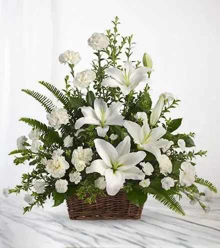 White lilies and carnations in a wicker basket