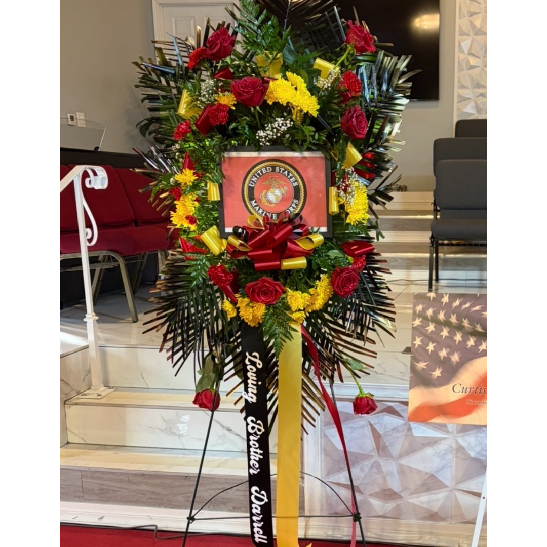 Standing floral tribute with red roses and yellow flowers on a display easel