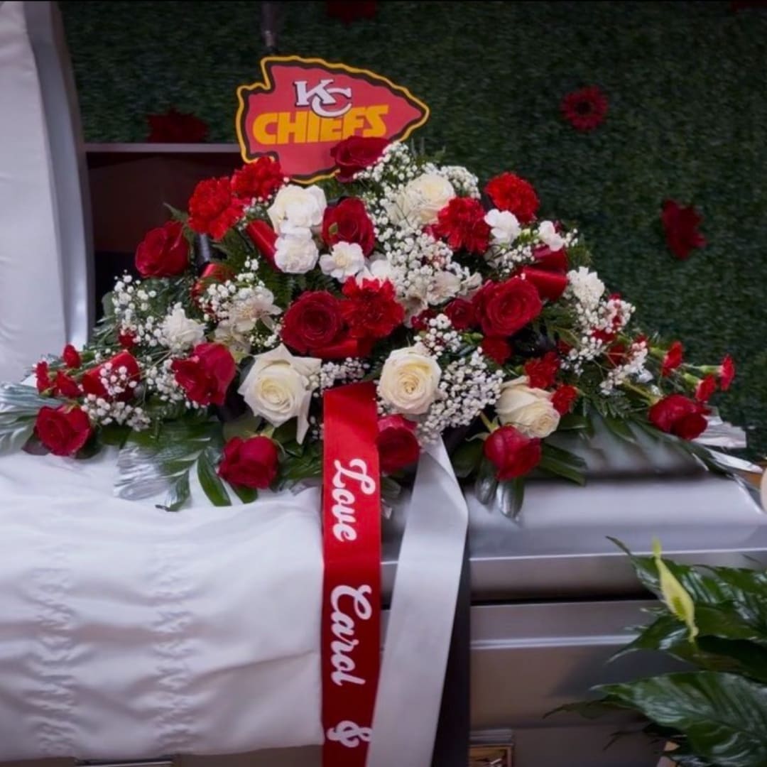 Red and white rose casket spray with a Chiefs sign and ribbon