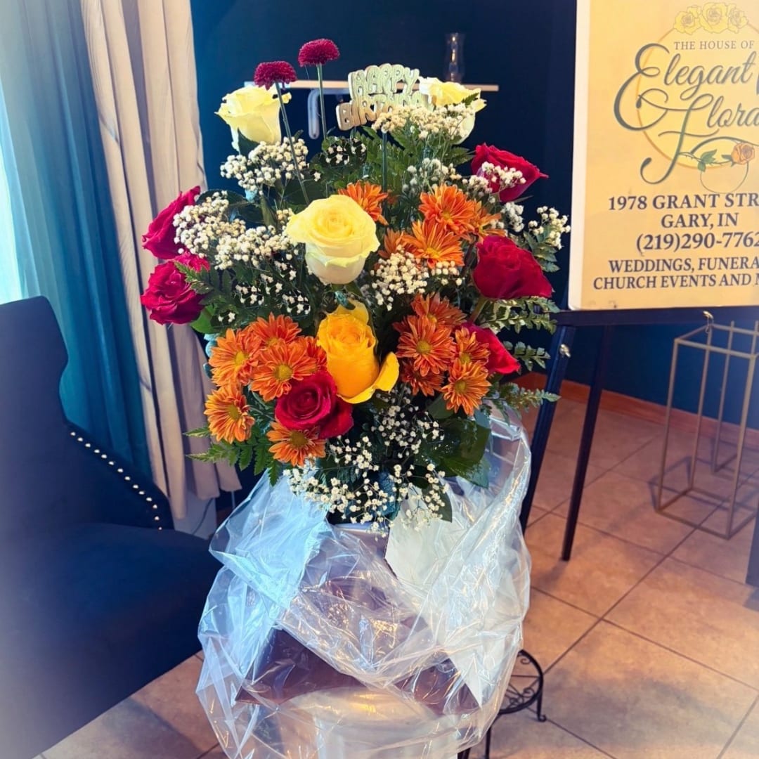 Mixed bouquet of roses and orange daisies in a vase