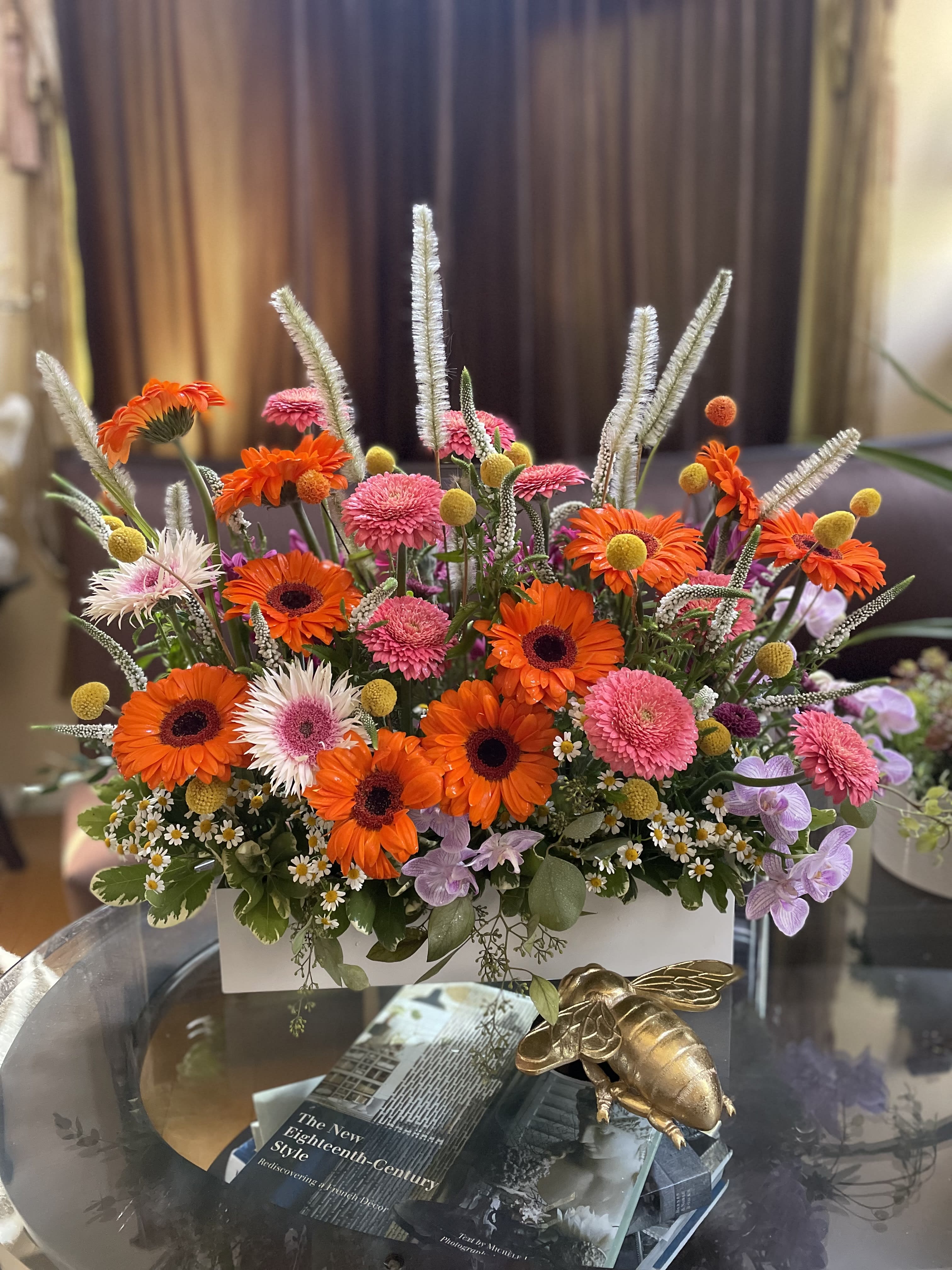 Bright mixed flower arrangement in a white rectangular container