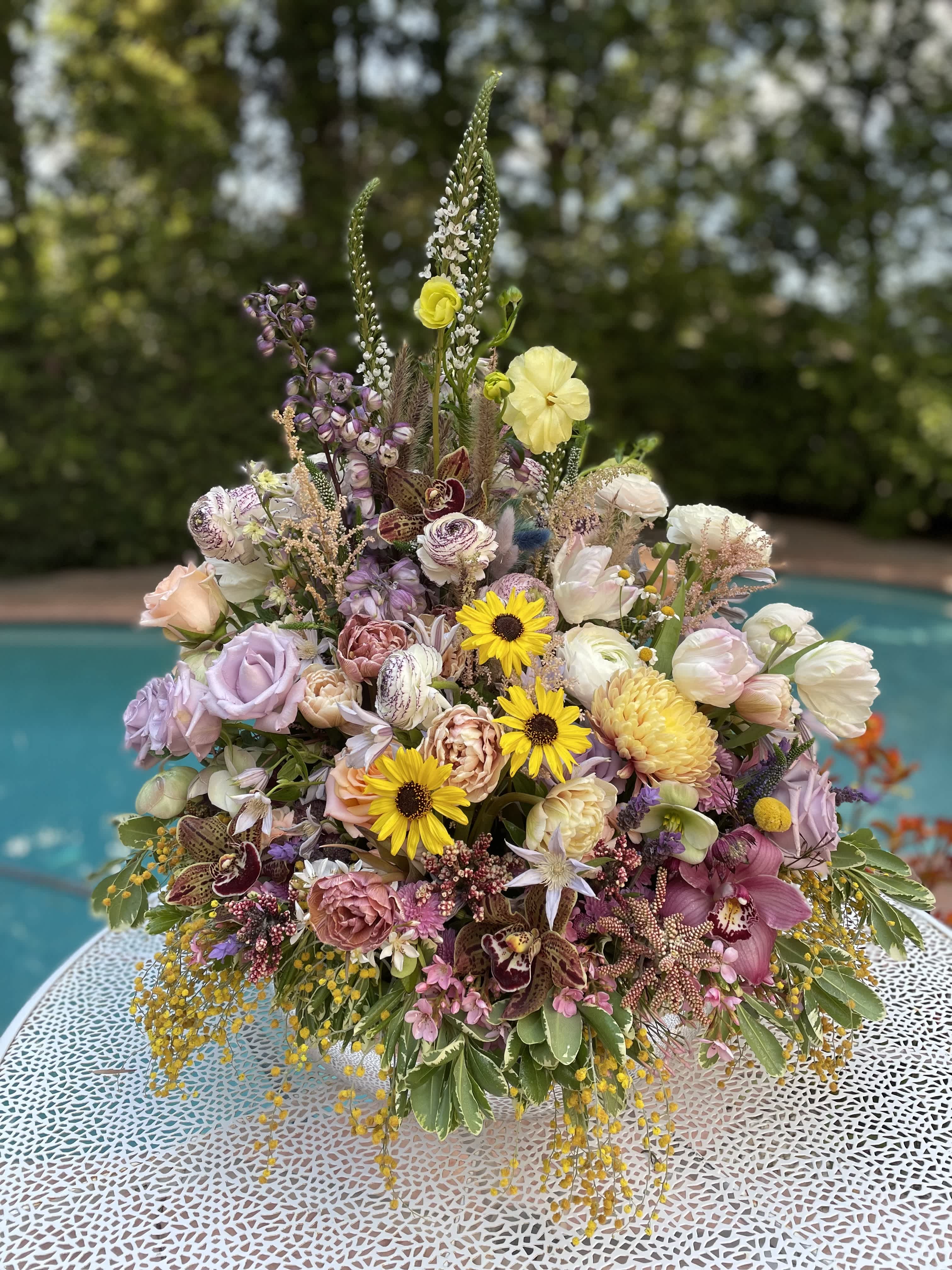 Large mixed bouquet with pastel flowers and tall spikes in a low container