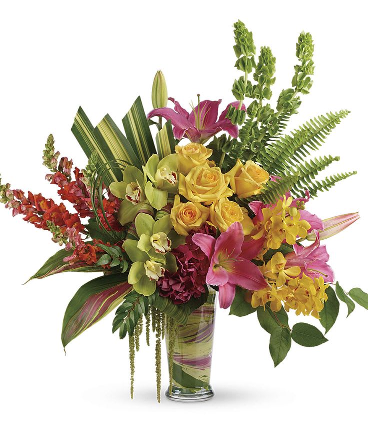 Mixed bouquet of yellow roses, pink lilies, and orchids in a glass vase