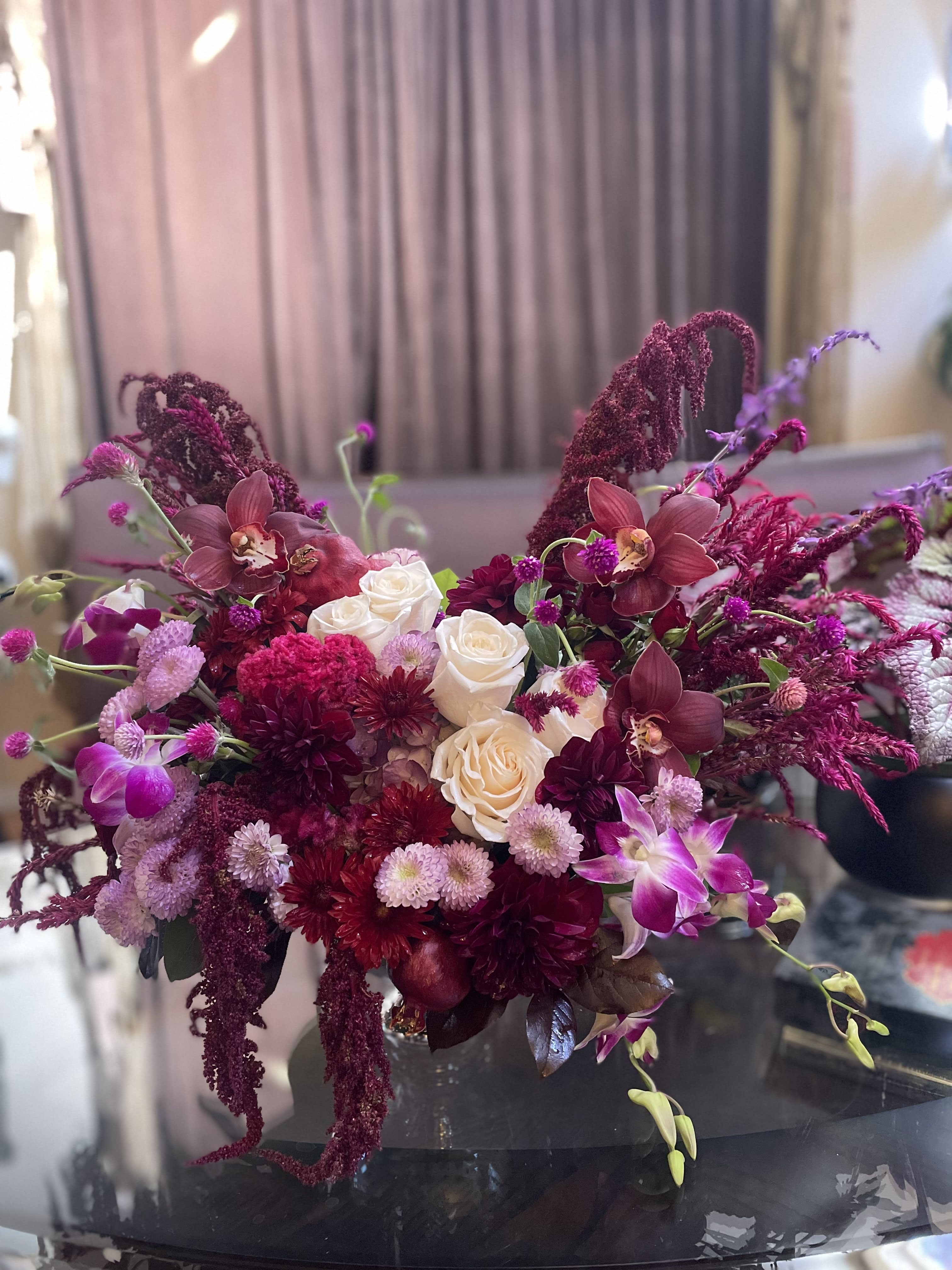 Bouquet of white roses and magenta orchids with burgundy blooms
