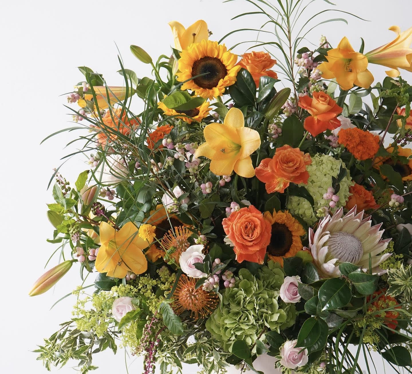 Large mixed bouquet with sunflowers, lilies, roses, and protea