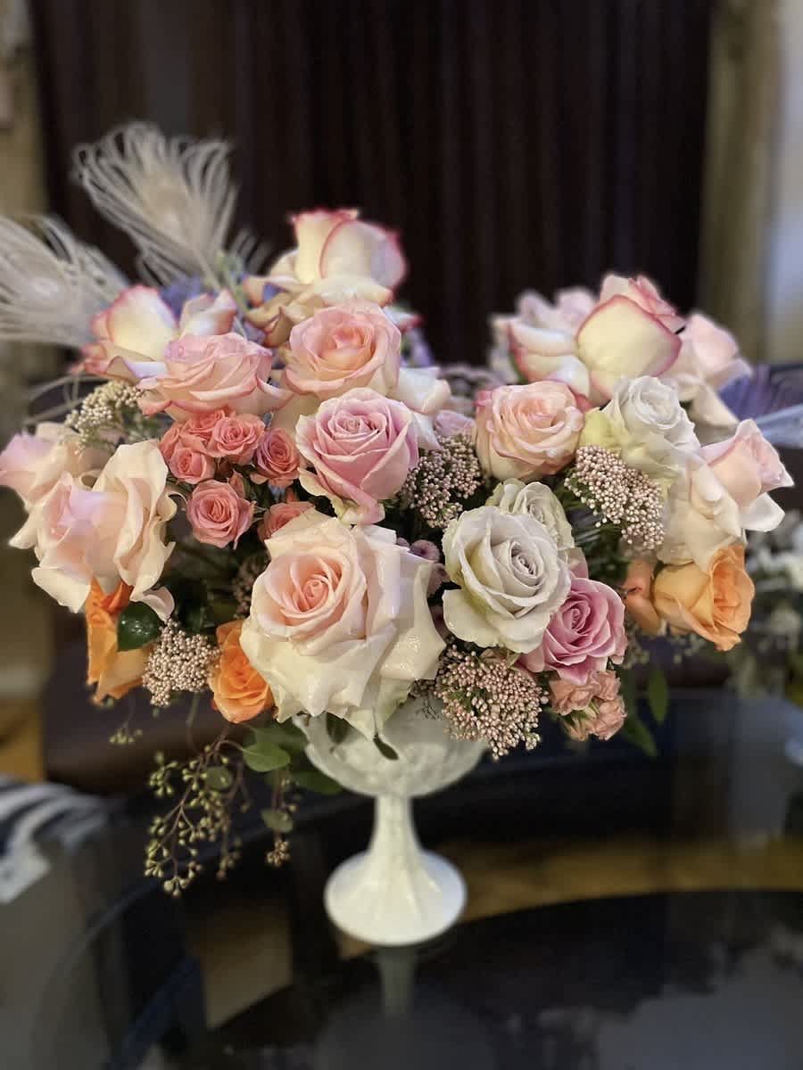 Bouquet of pastel roses in a white pedestal vase