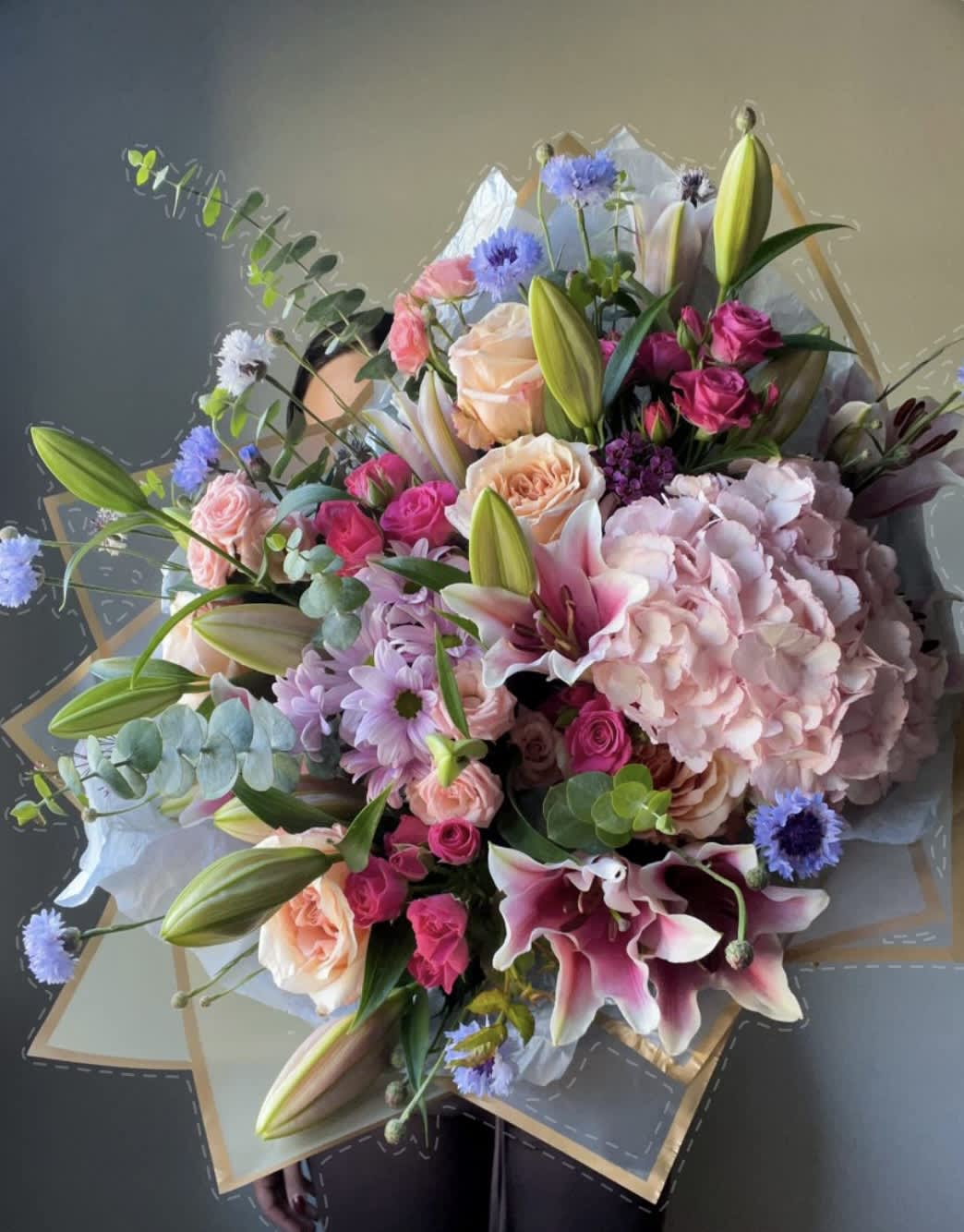 Mixed bouquet with pink roses, lilies, and hydrangea in paper wrap