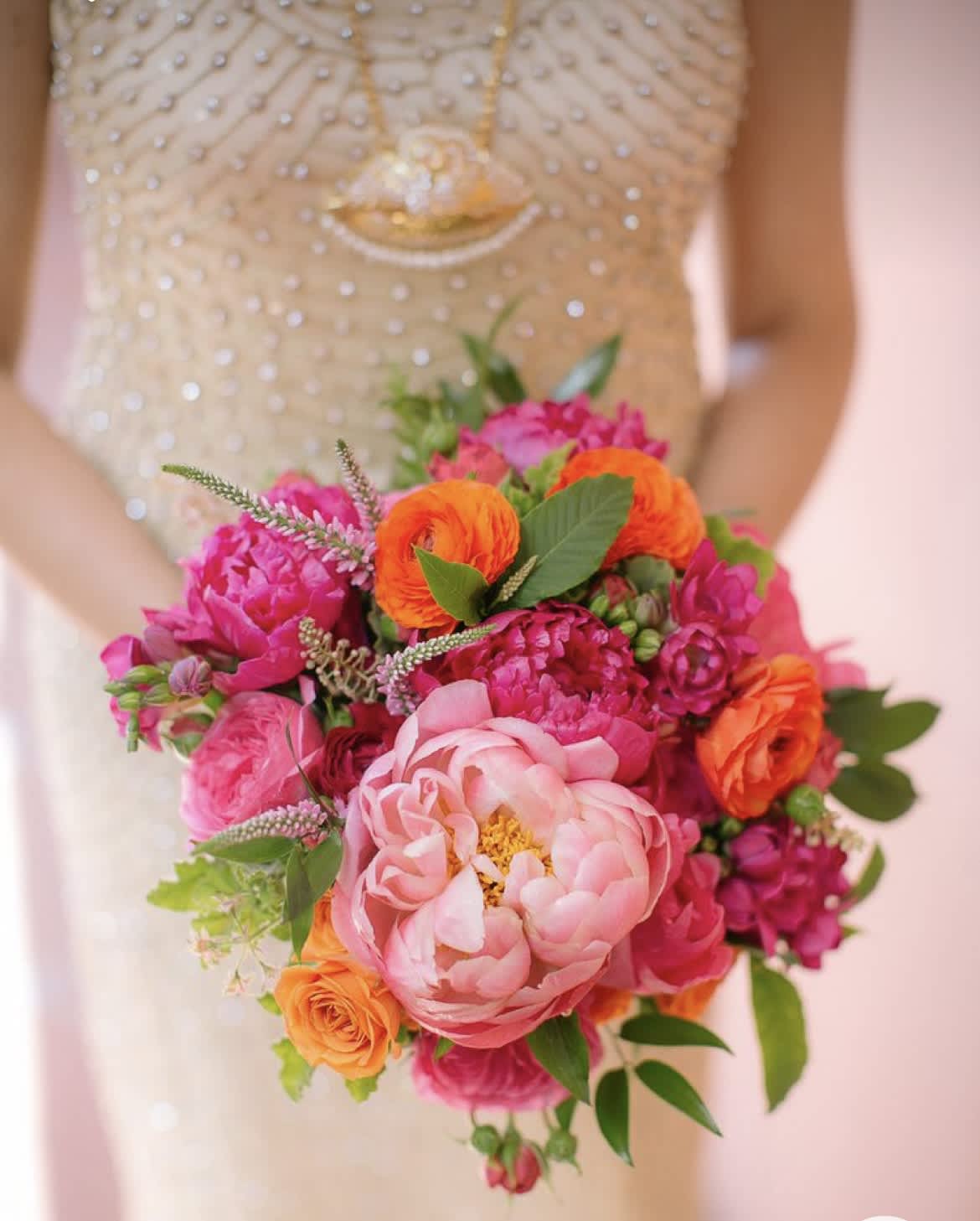 Bride holding a bright pink and orange bouquet