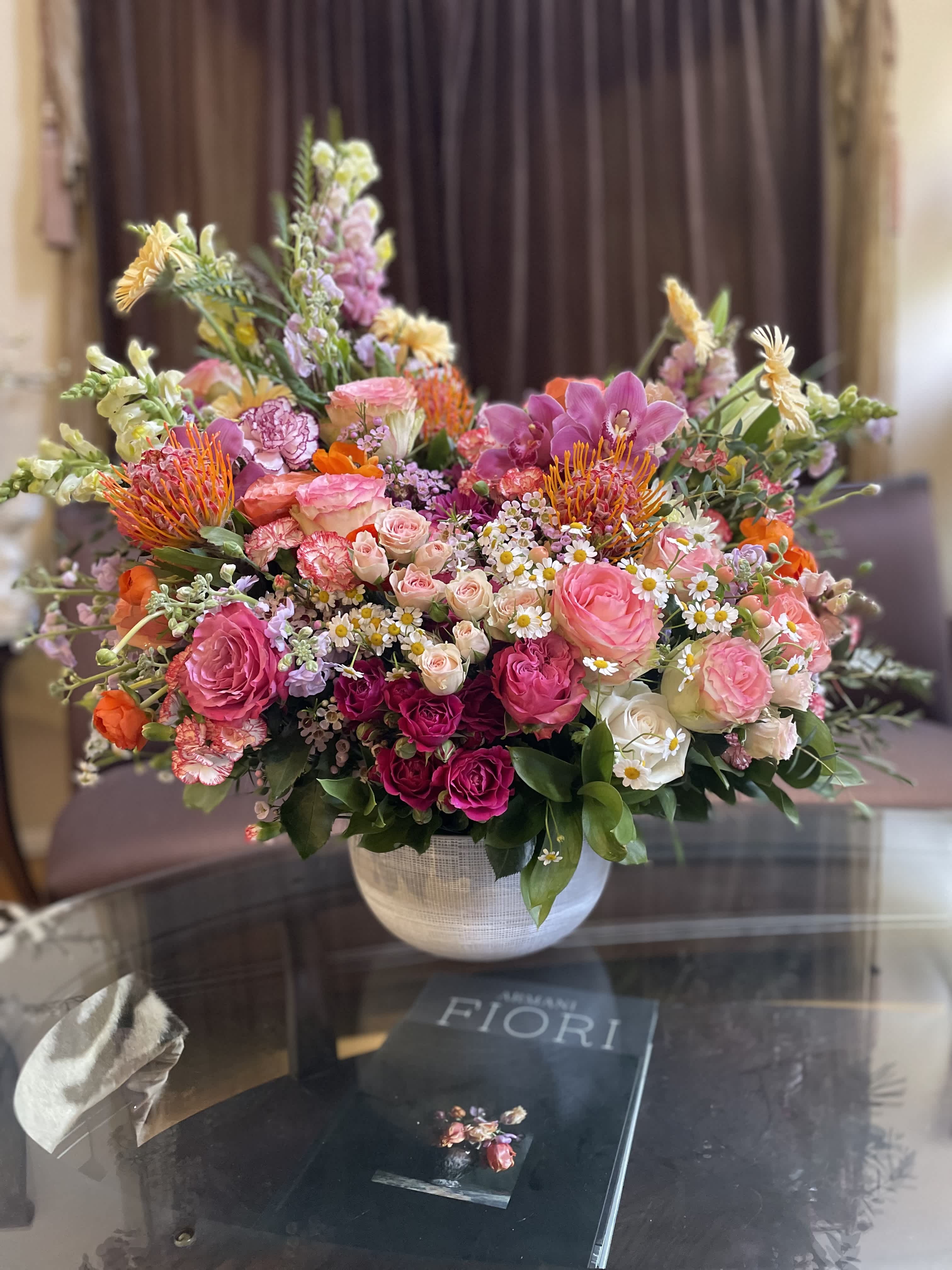 Large mixed bouquet in a white vase with pink, orange, and white blooms