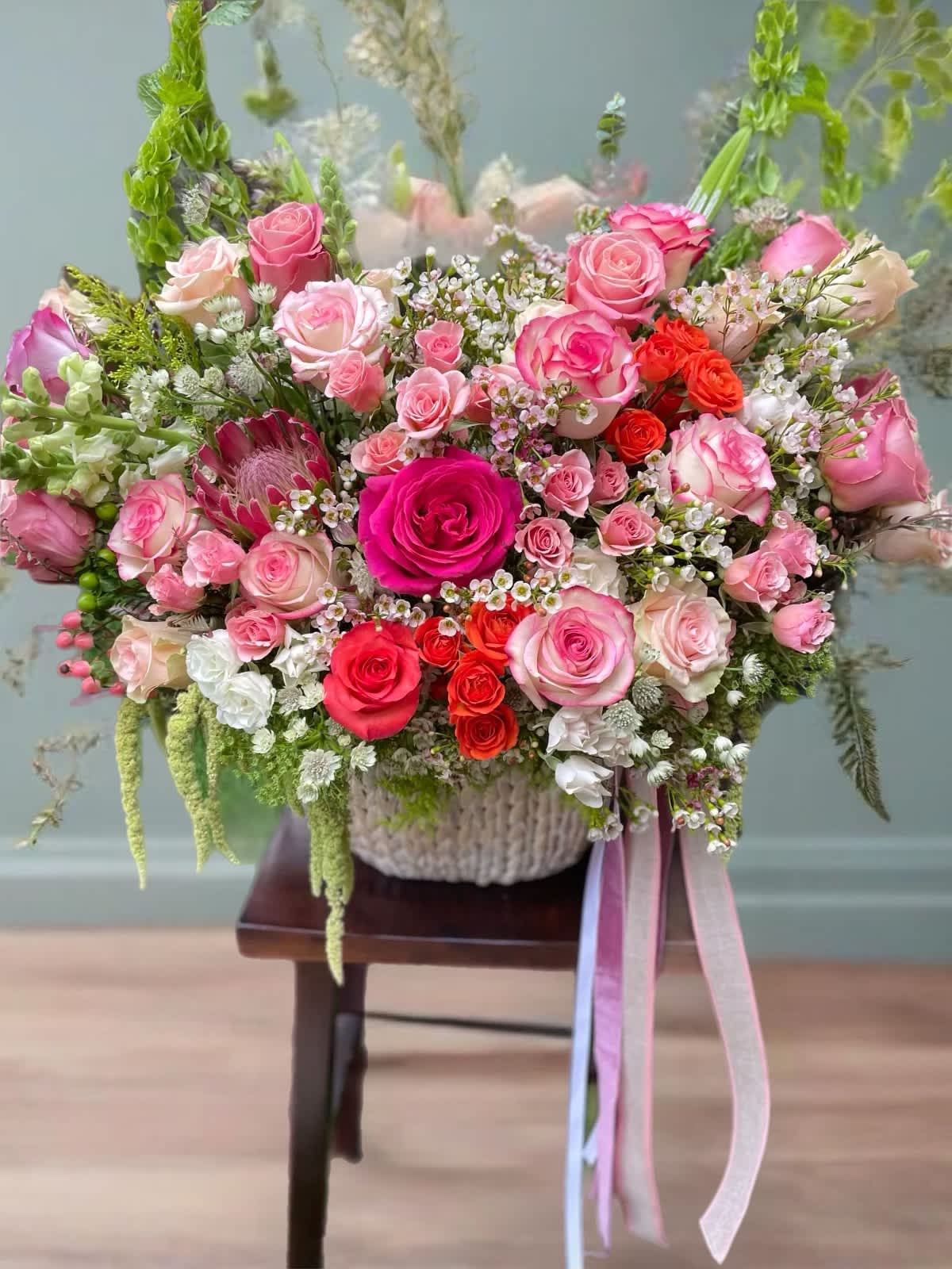 Large bouquet of pink and red roses in a woven basket