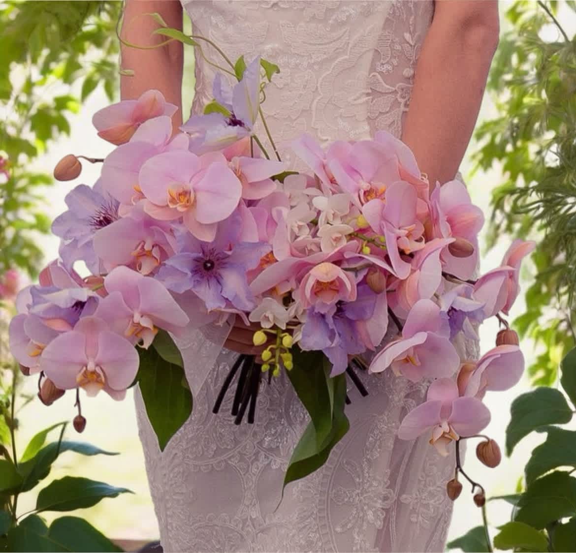 Bride holding a cascading bouquet of pink and lavender orchids