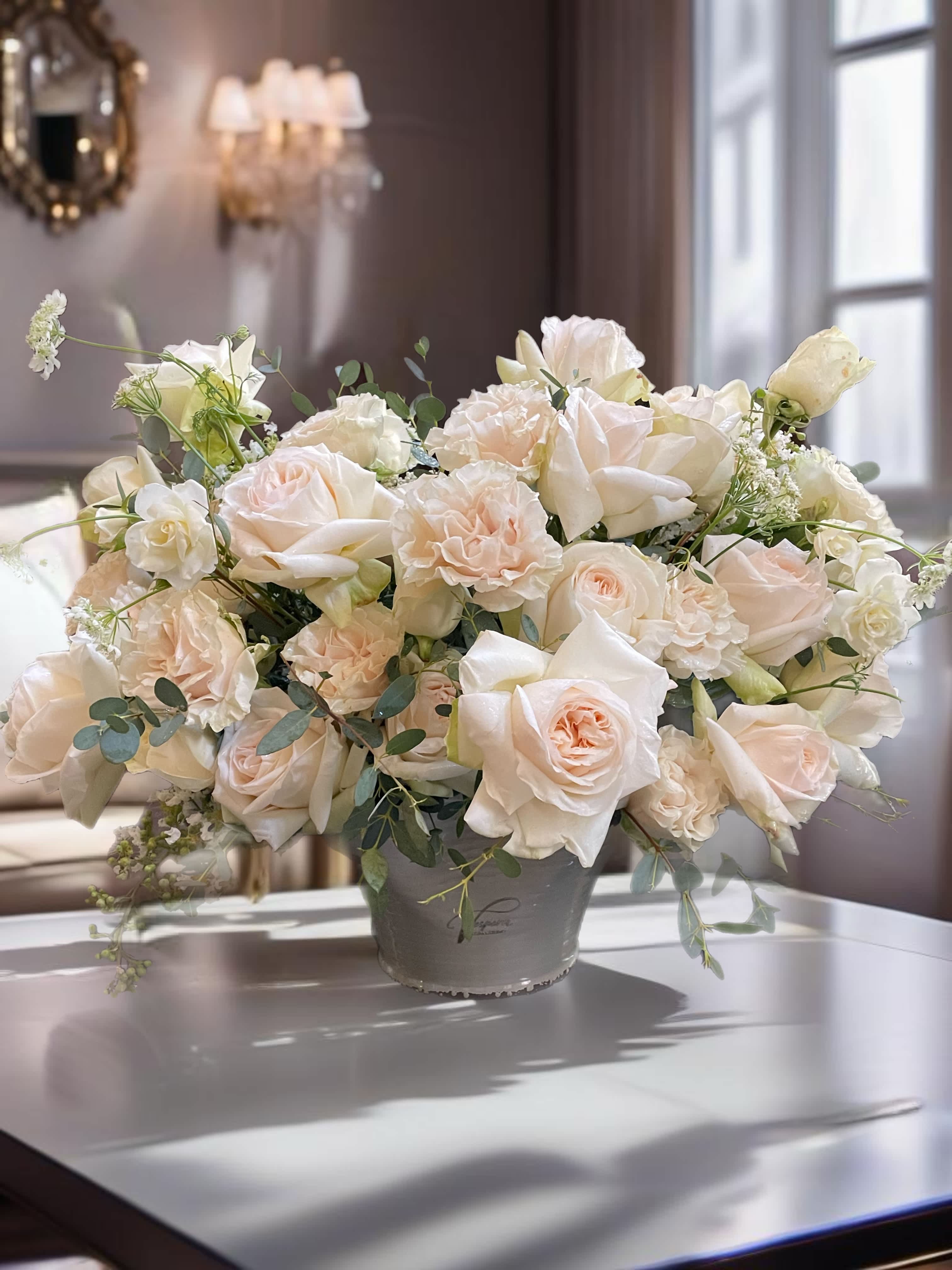 Cream roses and carnations in a gray vase