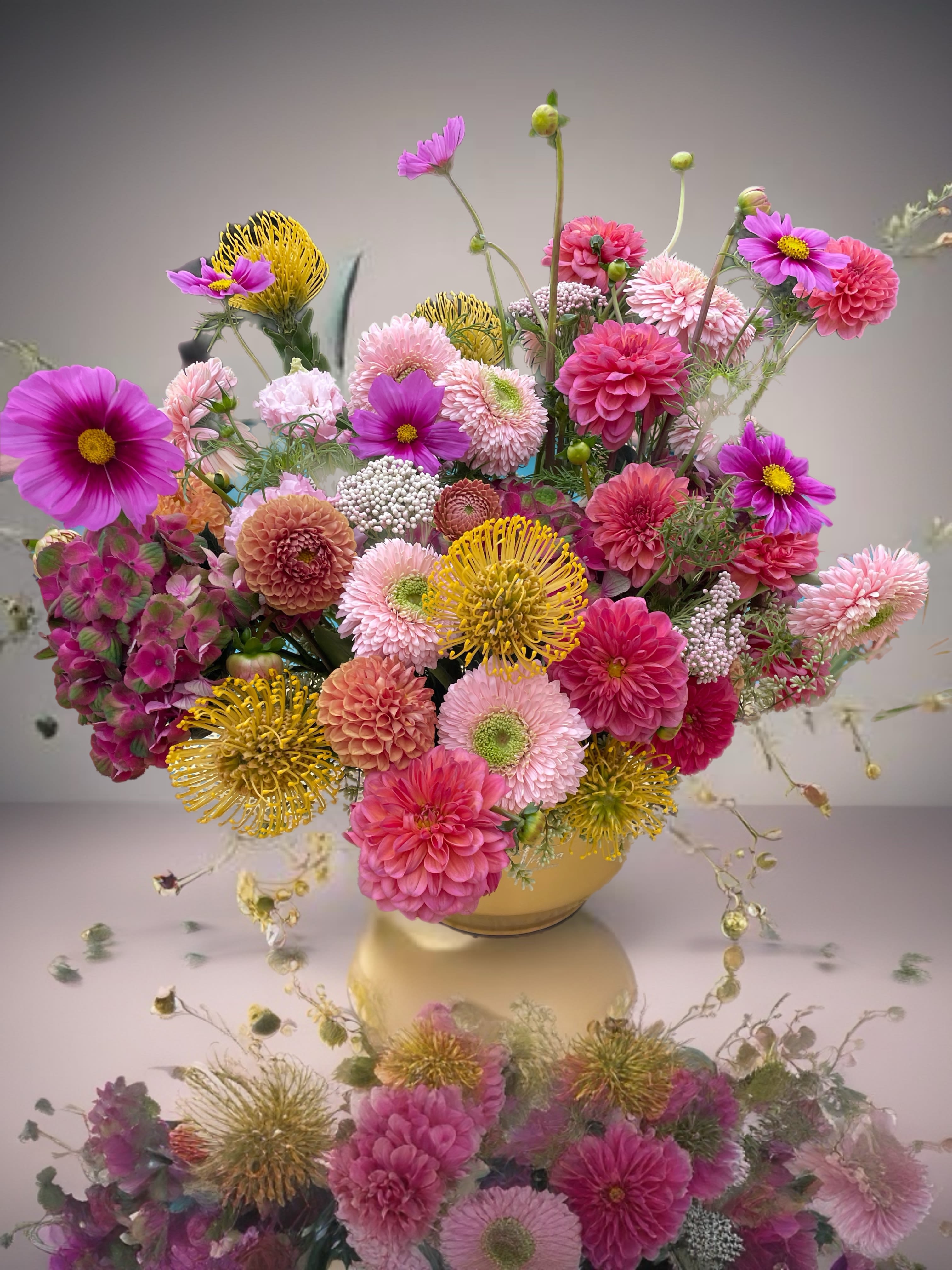 Pink and yellow mixed flower arrangement in a low vase