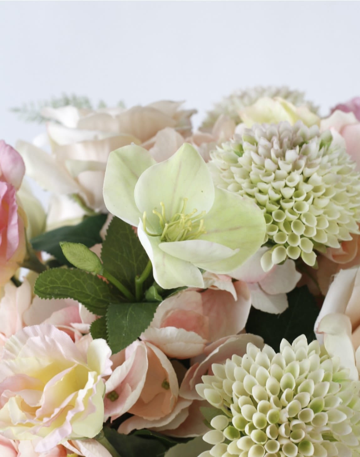 Pastel floral arrangement with pale pink and cream blooms and green-centered flowers