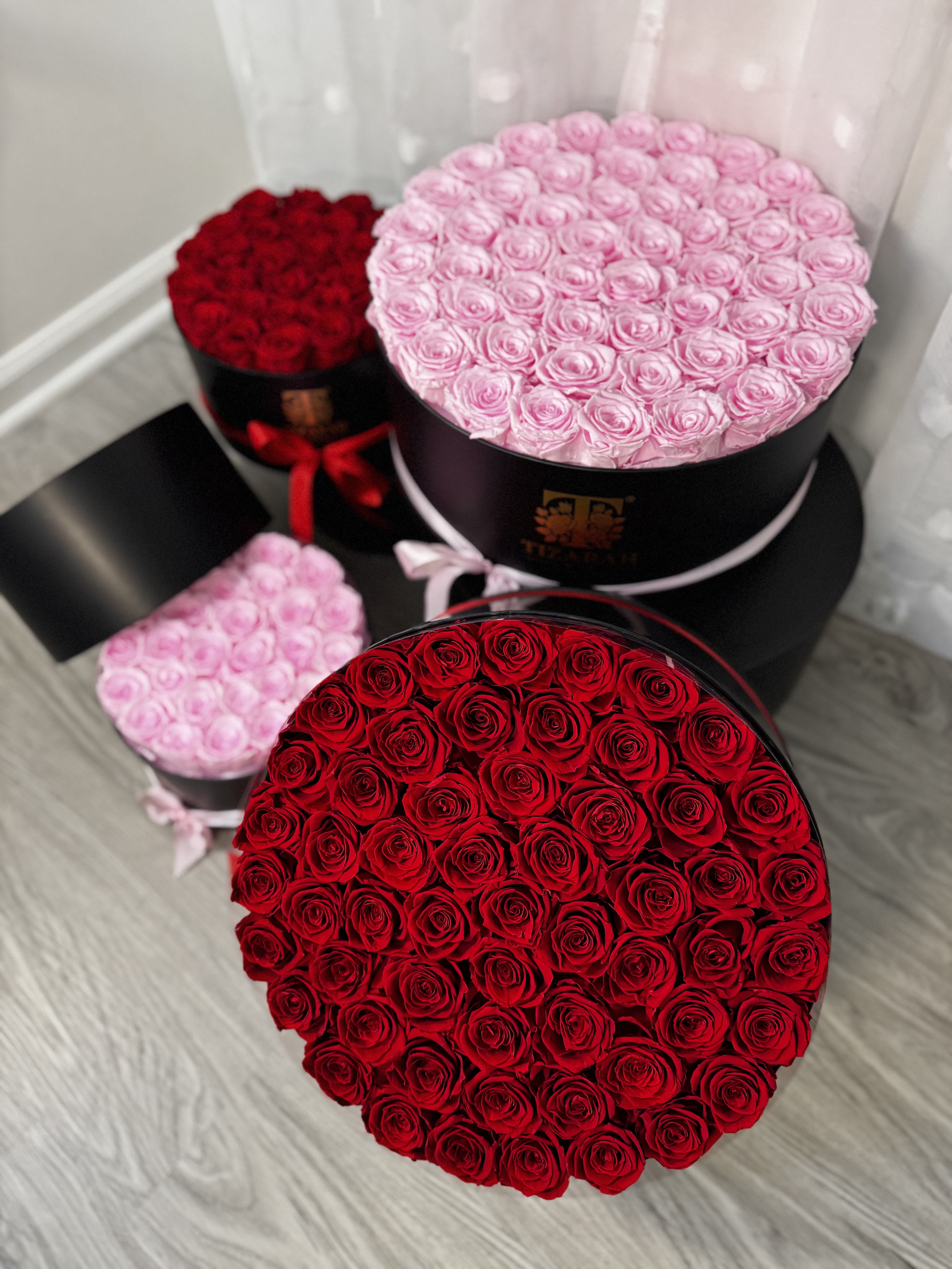 Round boxes filled with red and pink roses