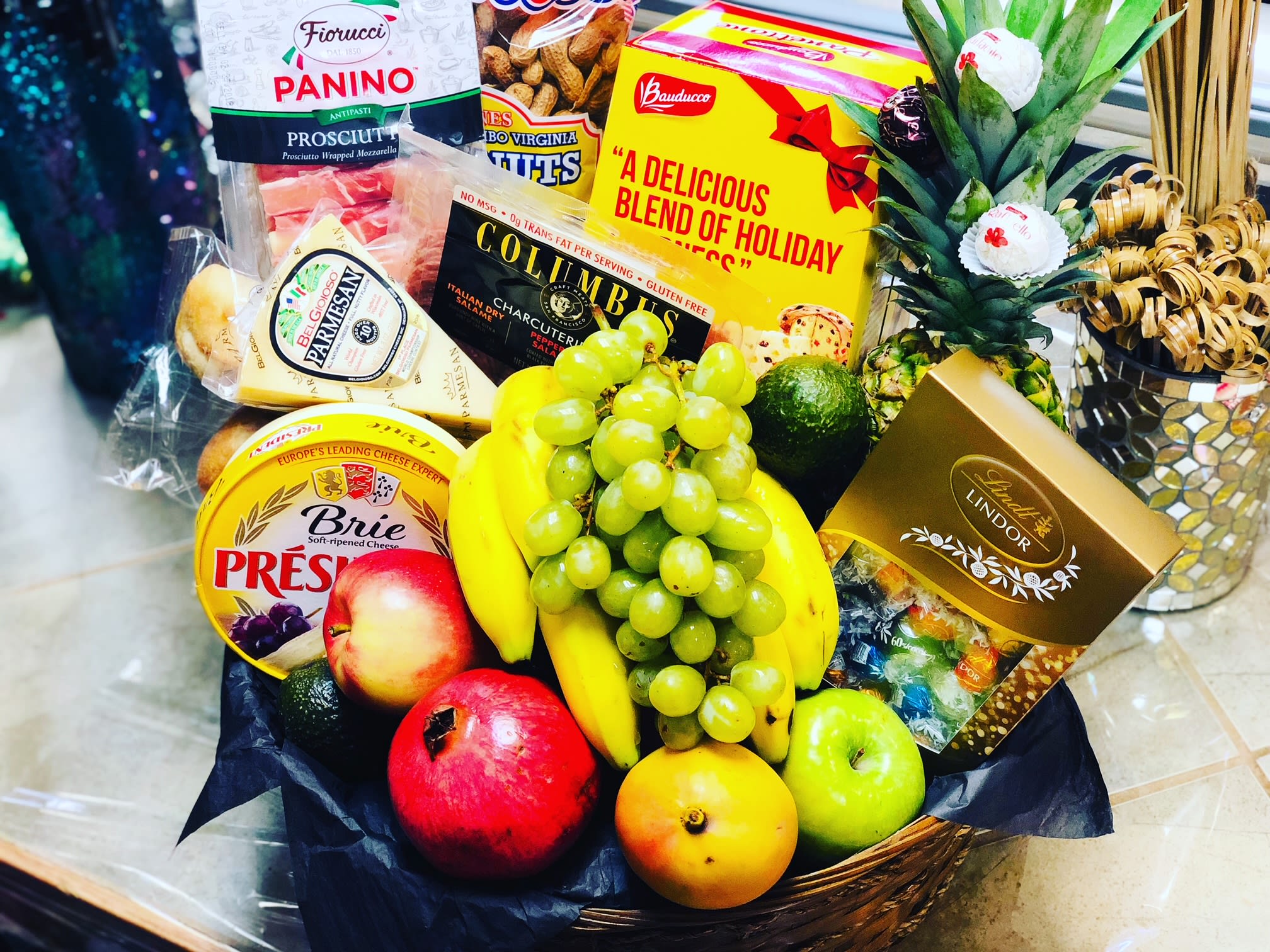 Gift basket with fruit, cheese, chocolates, and a pineapple centerpiece