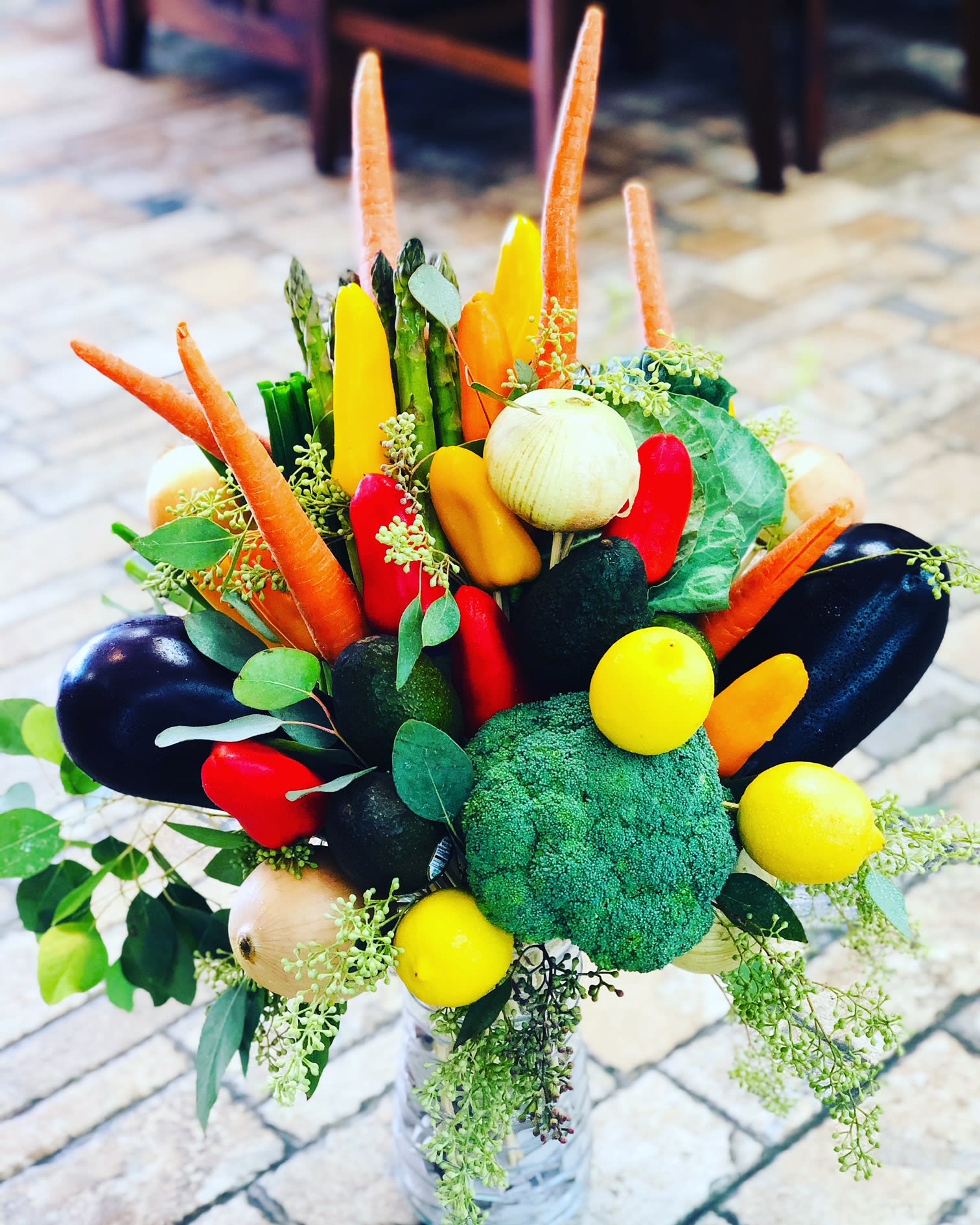 Vegetable bouquet with carrots, peppers, broccoli, onions, and greens in a vase