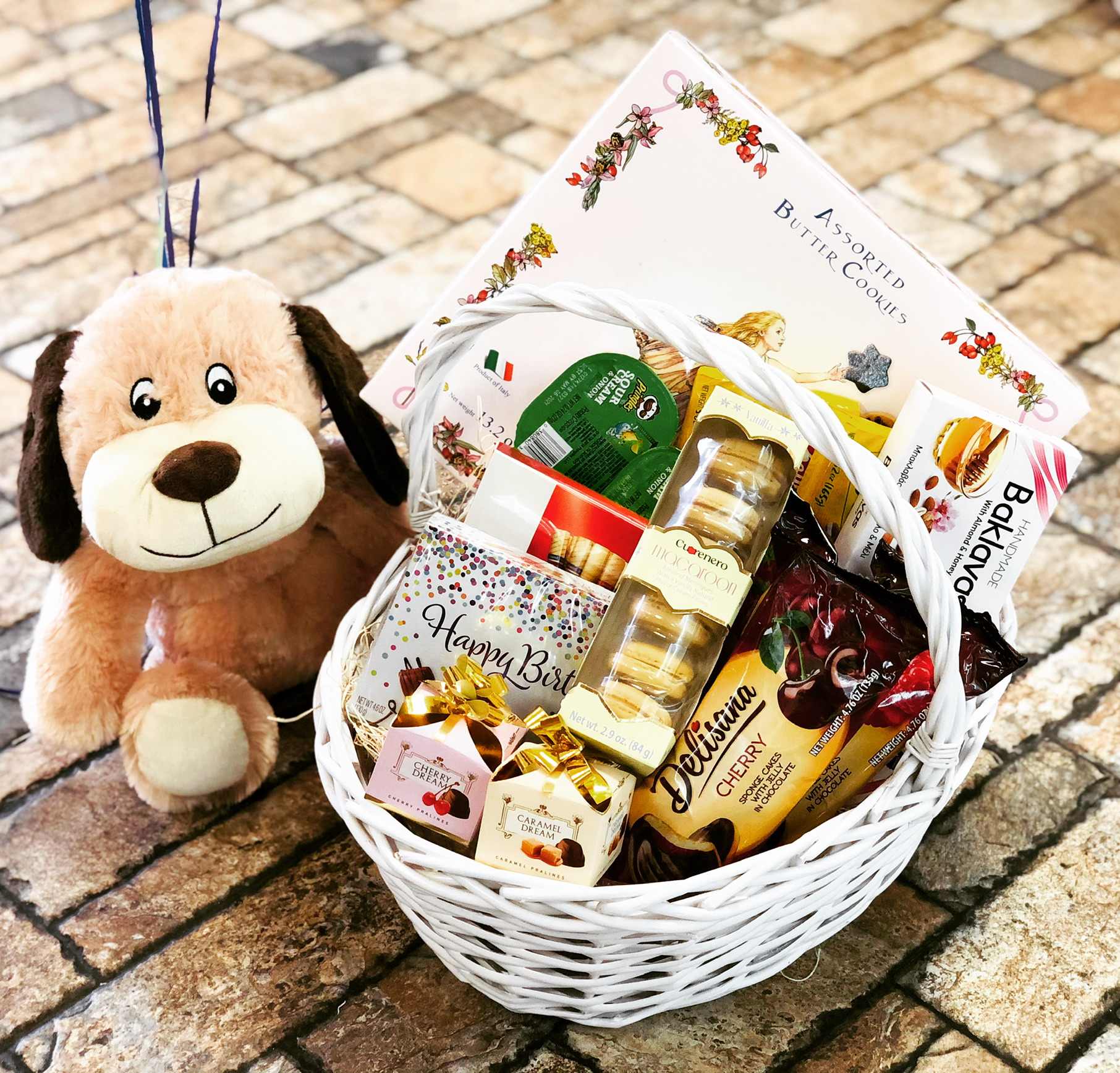 Gift basket with cookies, chocolates, and a plush dog