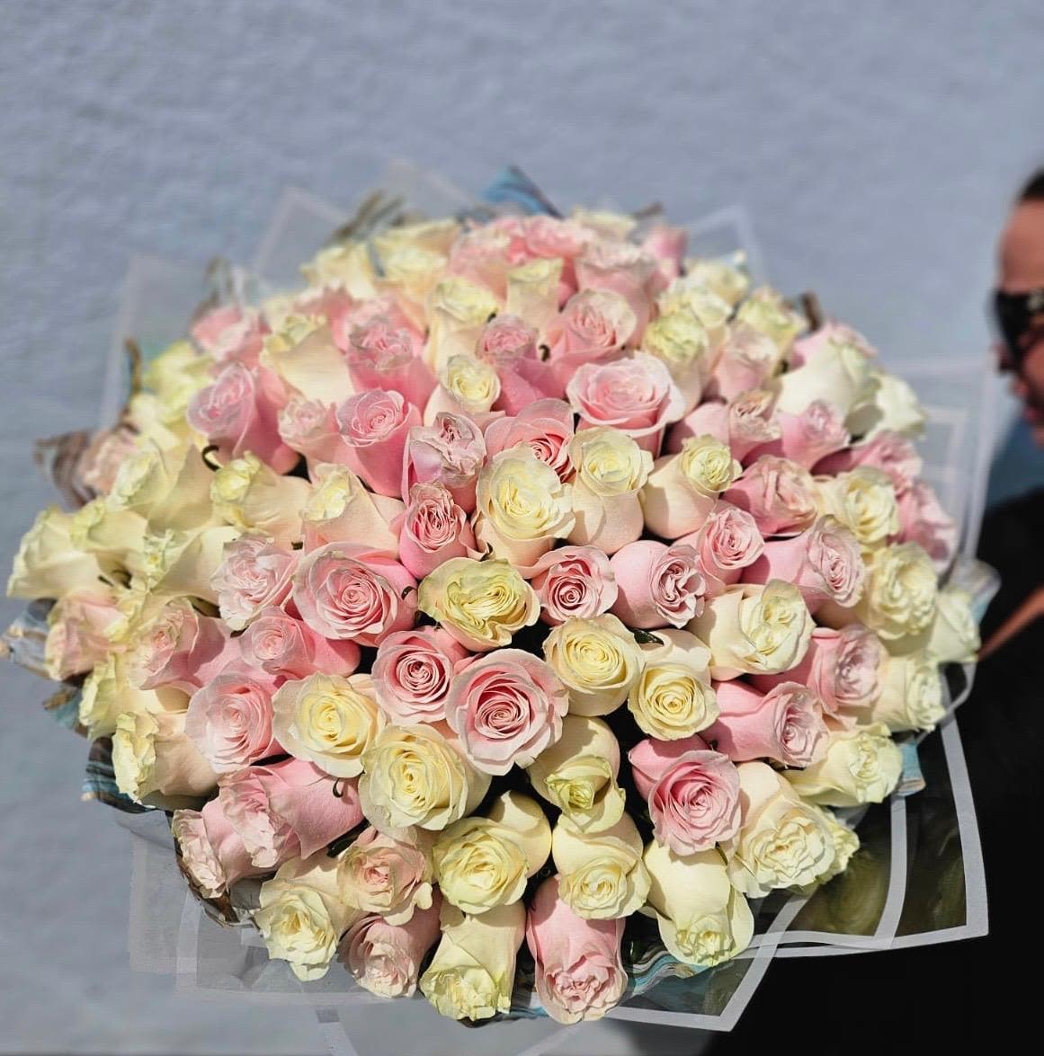 Large bouquet of pale pink and cream roses wrapped in clear paper