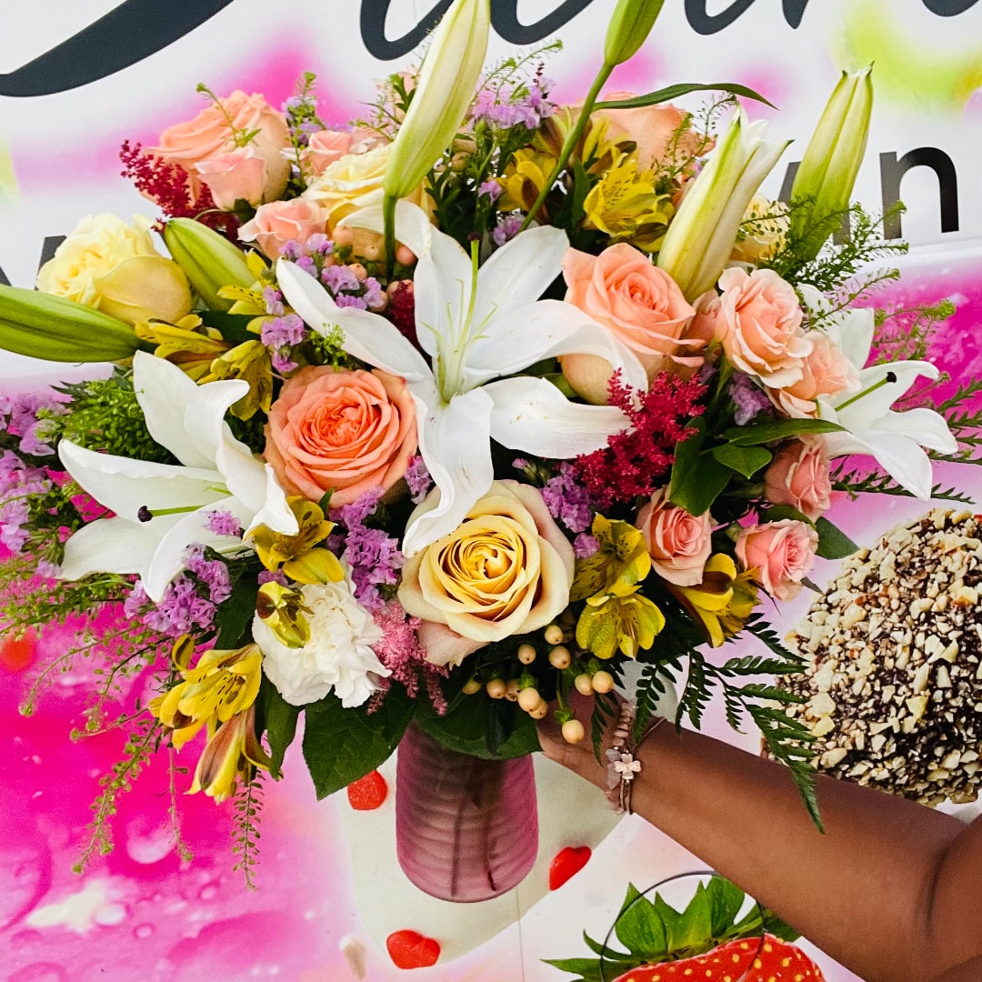 Bouquet of roses and lilies in a pink vase