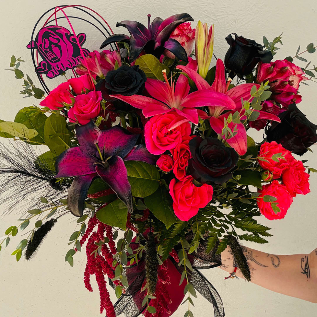 Bouquet of hot pink and black flowers with lilies and roses