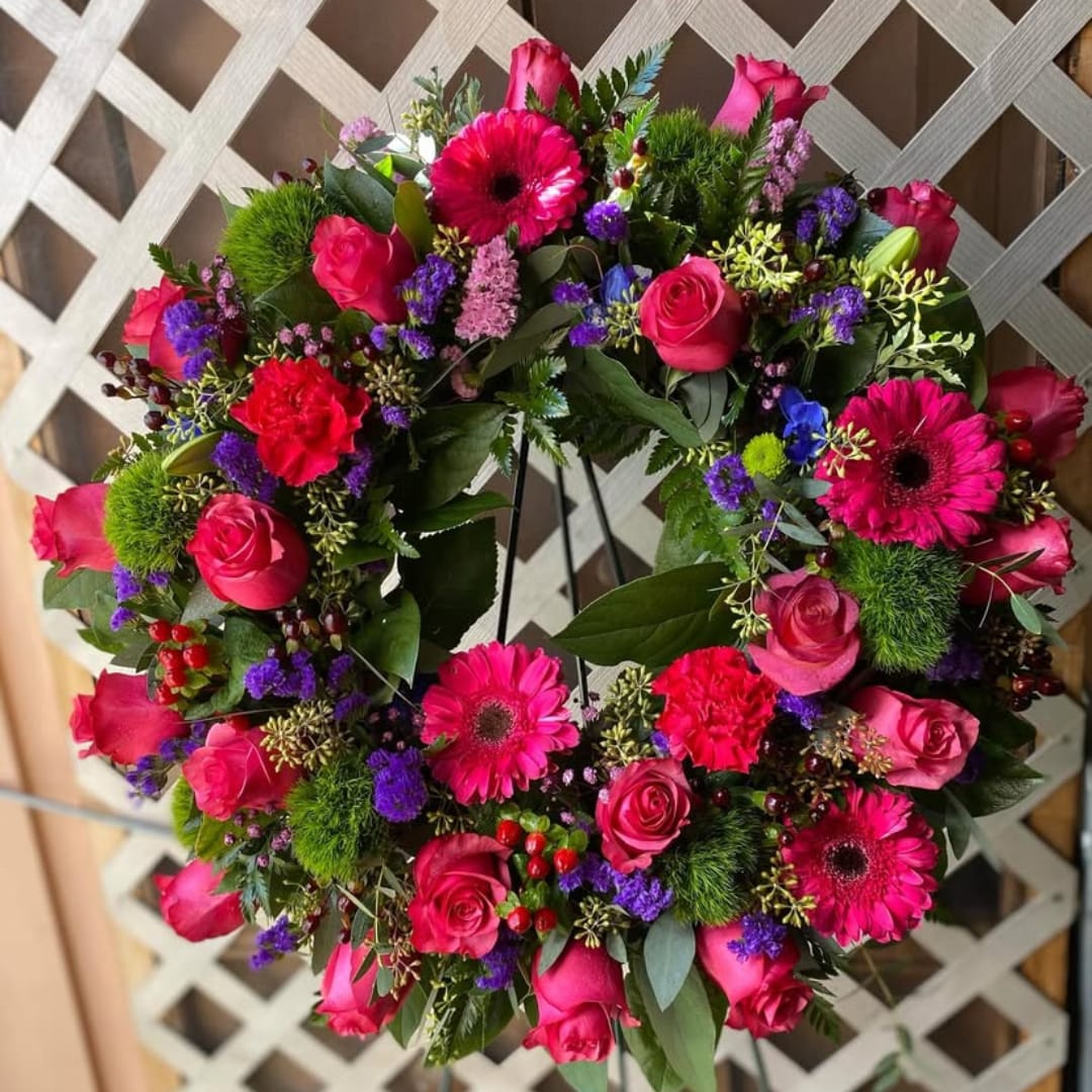 Heart-shaped floral wreath with pink roses and bright gerbera daisies