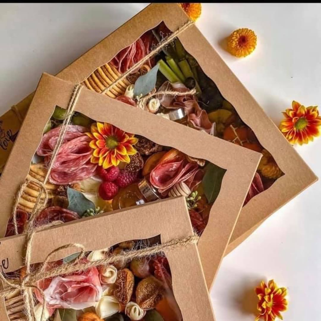 Three kraft paper gift boxes filled with flowers and dried botanicals