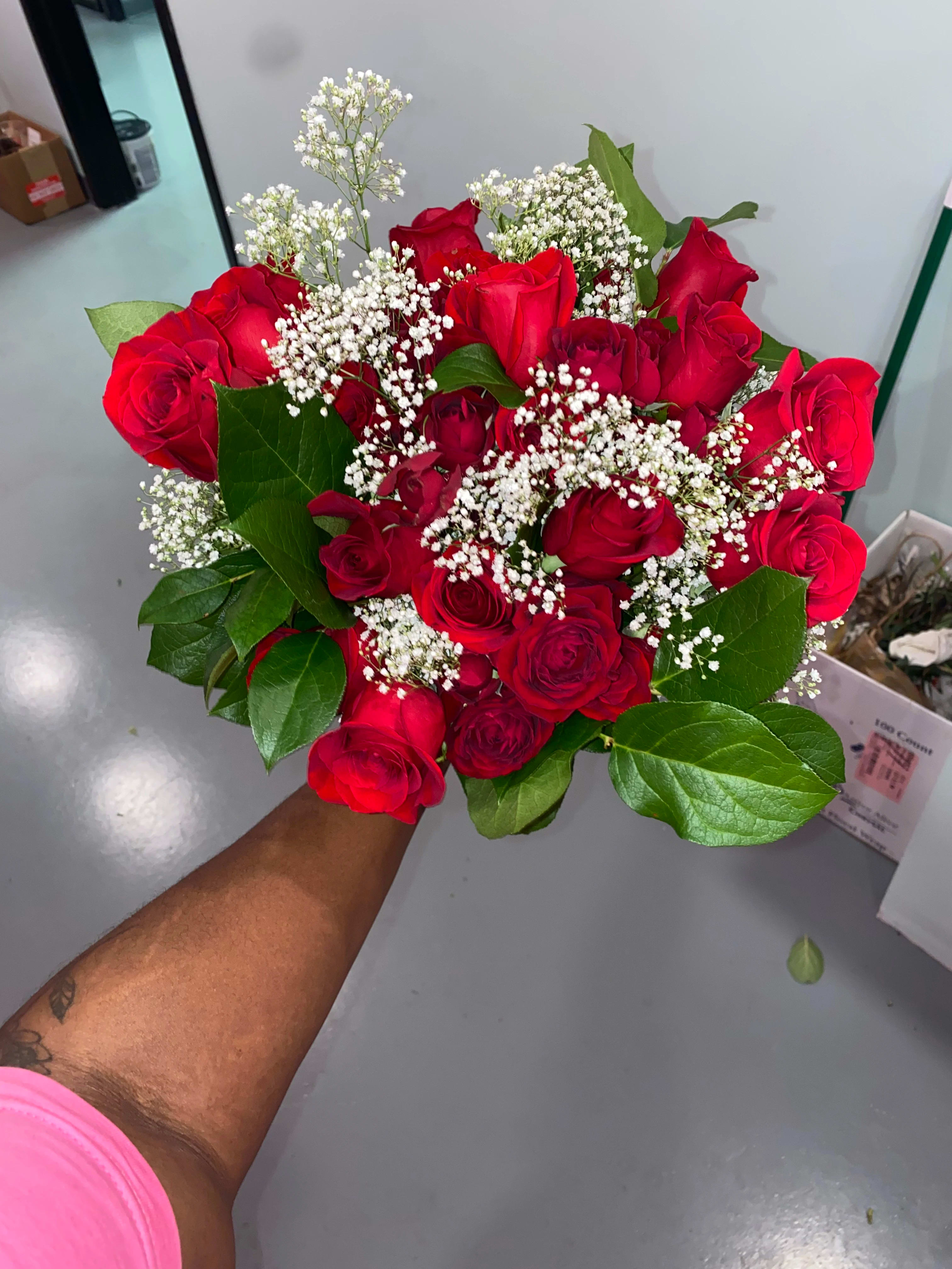 Handheld bouquet of red roses with white baby's breath