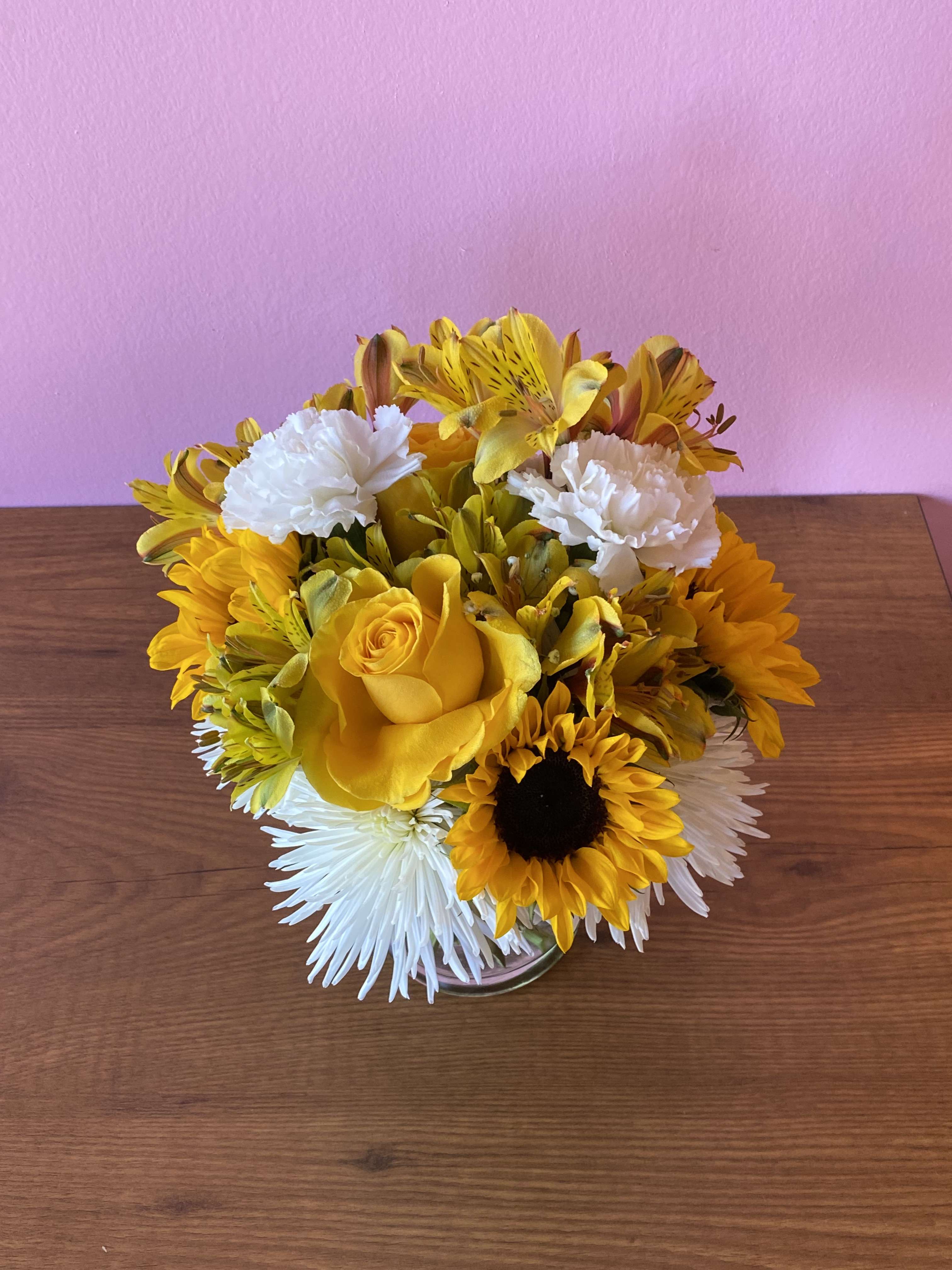Yellow and white flower arrangement in a clear glass vase