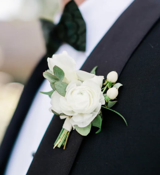 White boutonniere pinned to a black suit jacket