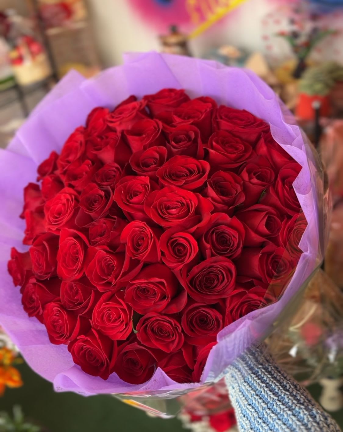 Large bouquet of red roses wrapped in lavender paper