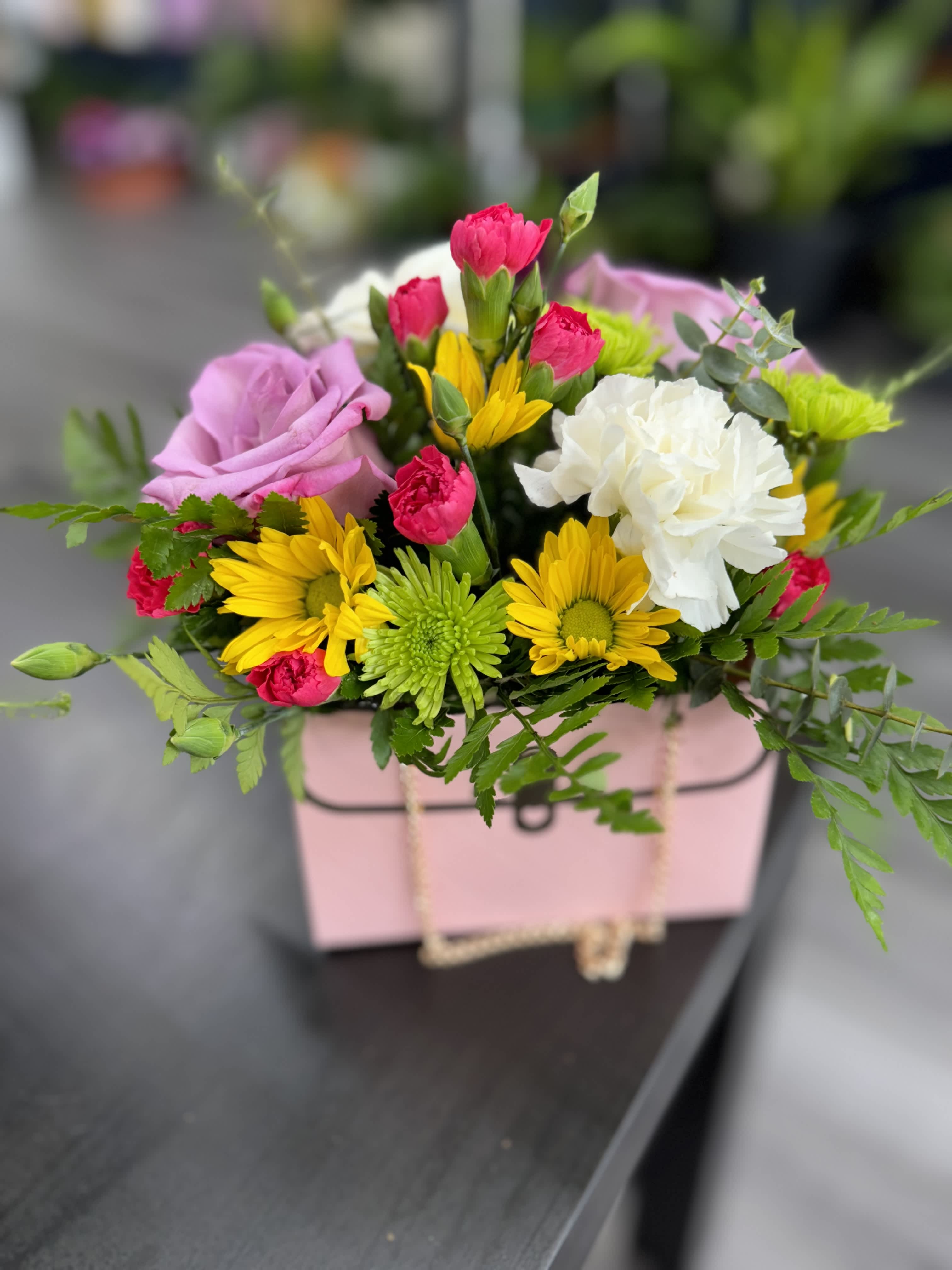 Mixed bouquet in a pink gift box with roses, carnations, and daisies