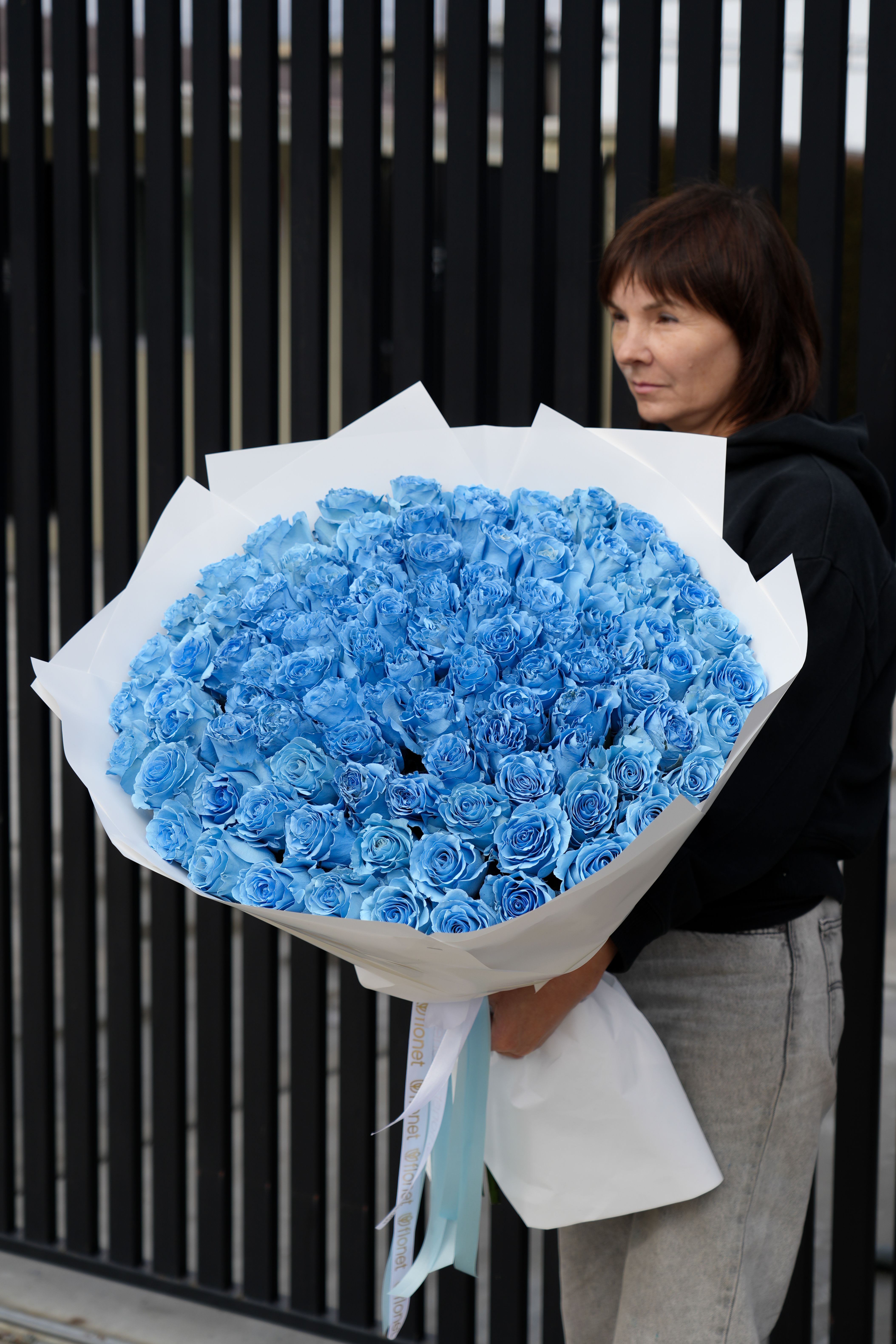 Large bouquet of blue roses wrapped in white paper
