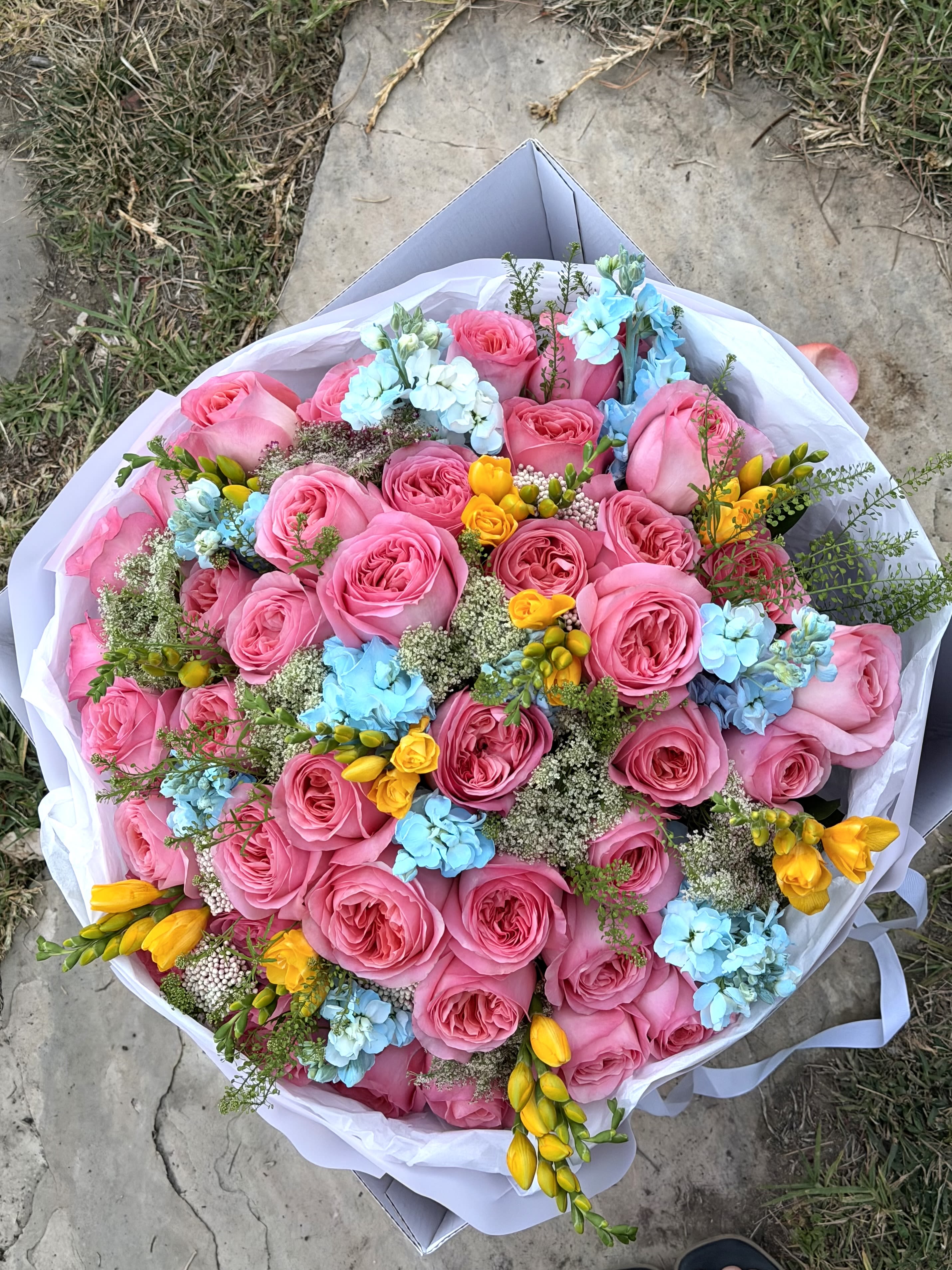 Candy Skies Bouqet  -  joyful explosion of color designed to brighten someone’s entire week. Cotton Candy Skies features premium garden roses in vibrant pink tones accented with delicate blue hydrangea, golden freesia, and airy seasonal textures. The unexpected combination of pink, sky blue, and sunshine yellow creates a playful yet luxurious bouquet that feels both romantic and uplifting.  Perfect for birthdays, congratulations, celebrations, new beginnings, or simply making someone’s day unforgettable.