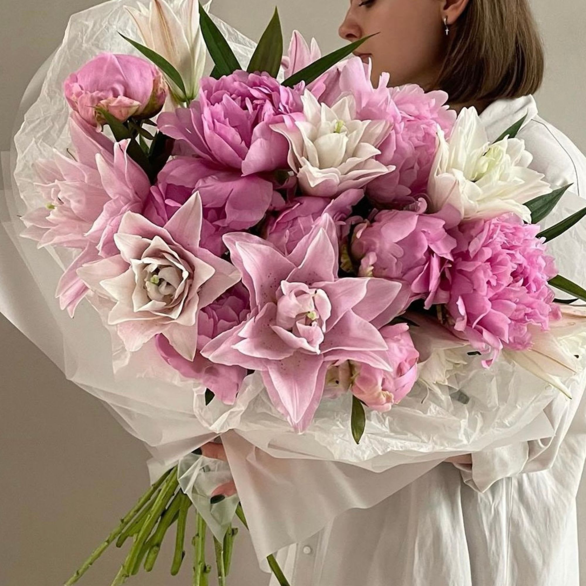 Woman holding a large bouquet of pink and white flowers