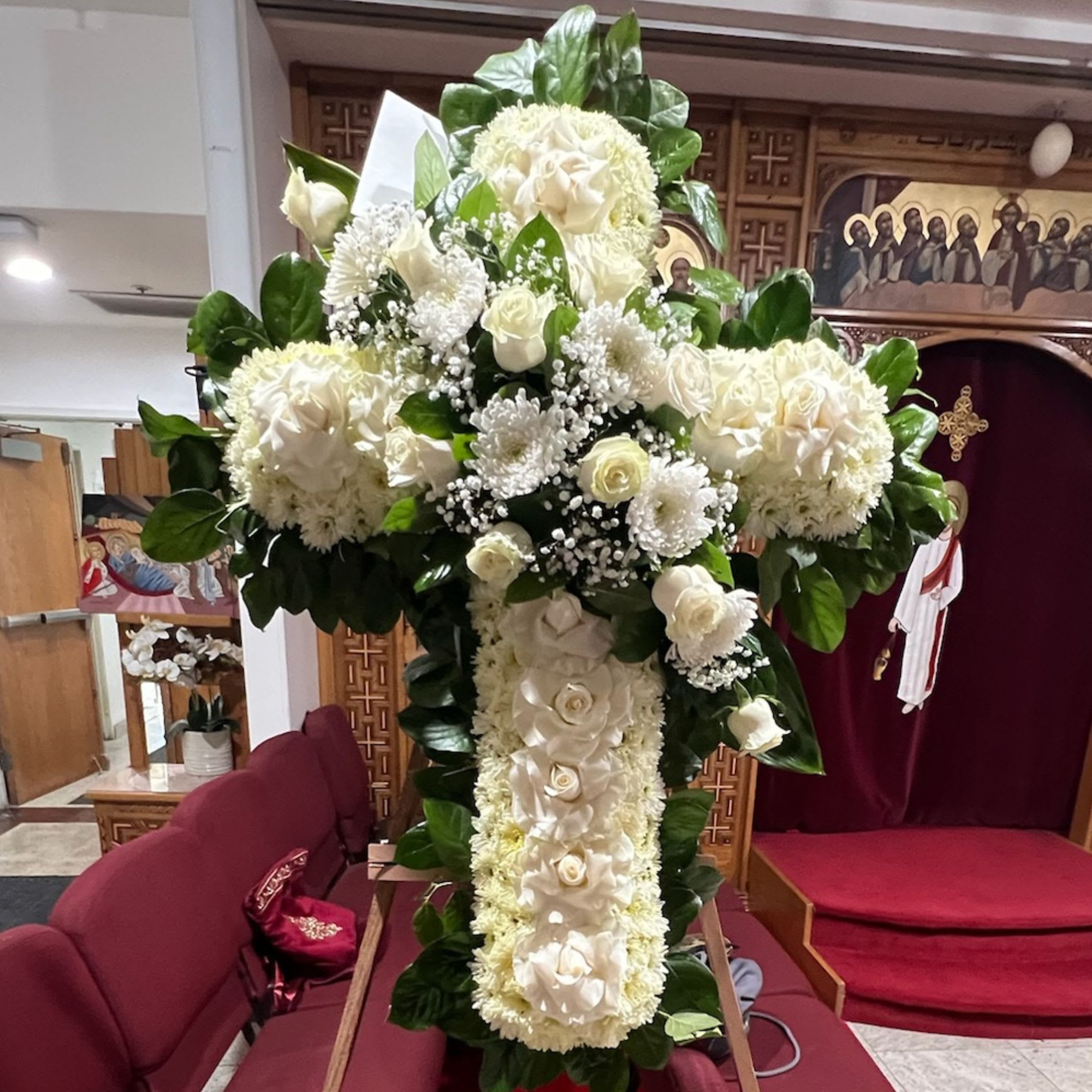 Large white floral cross arrangement with roses and chrysanthemums