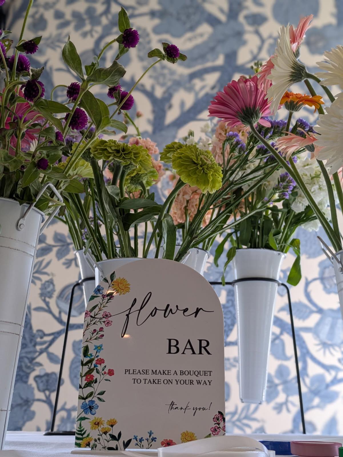 Flower bar display with mixed bouquets in white metal buckets