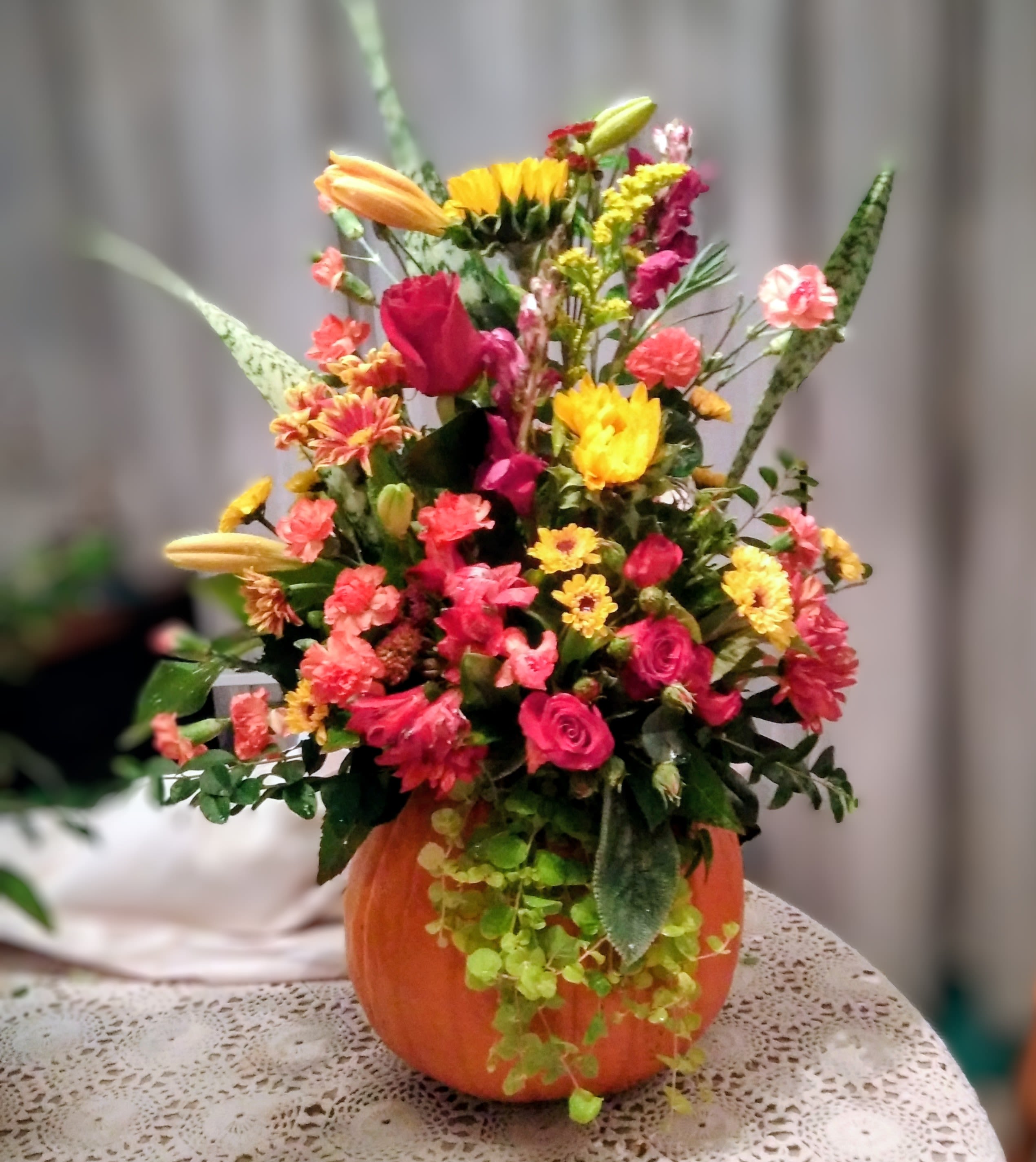 Colorful mixed flower arrangement in an orange pumpkin container