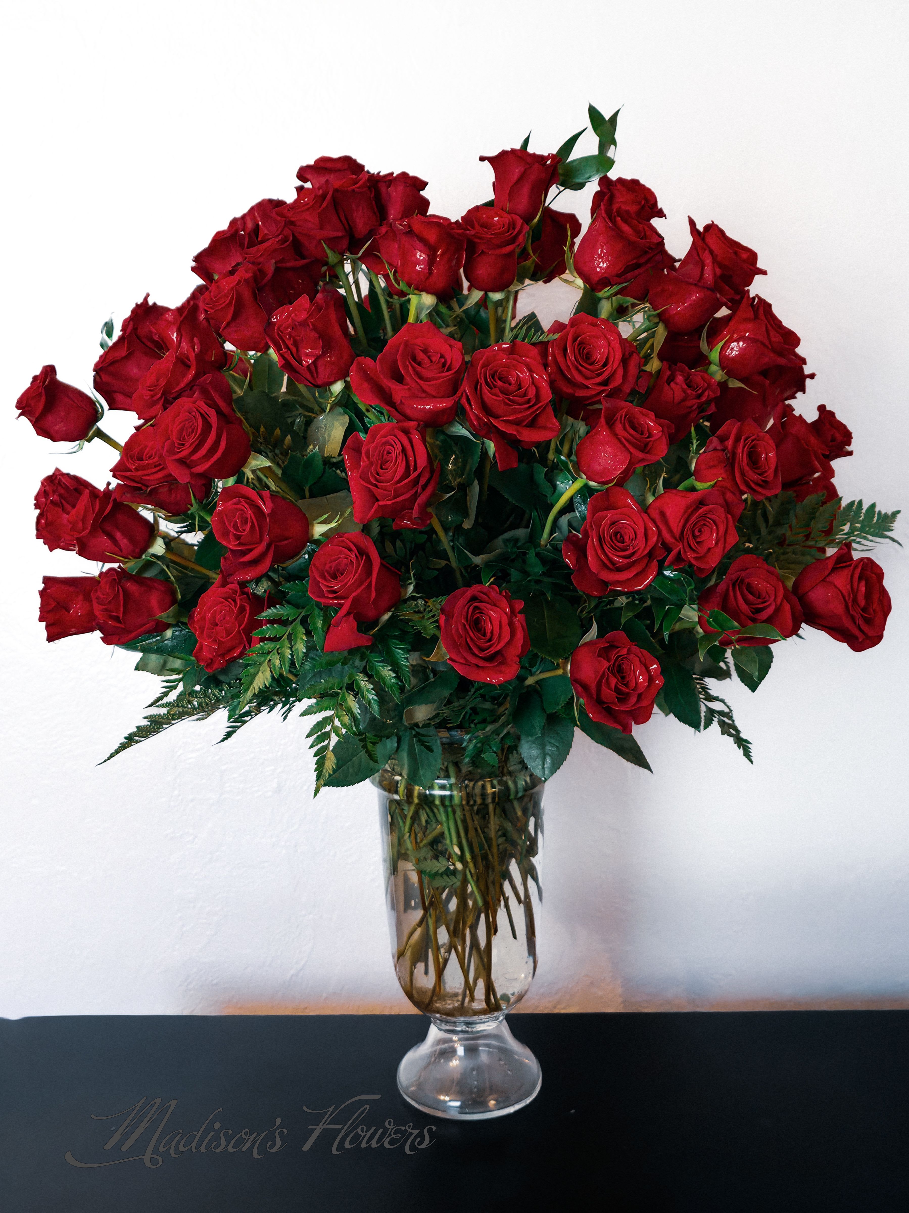 Red roses arranged in a clear glass vase