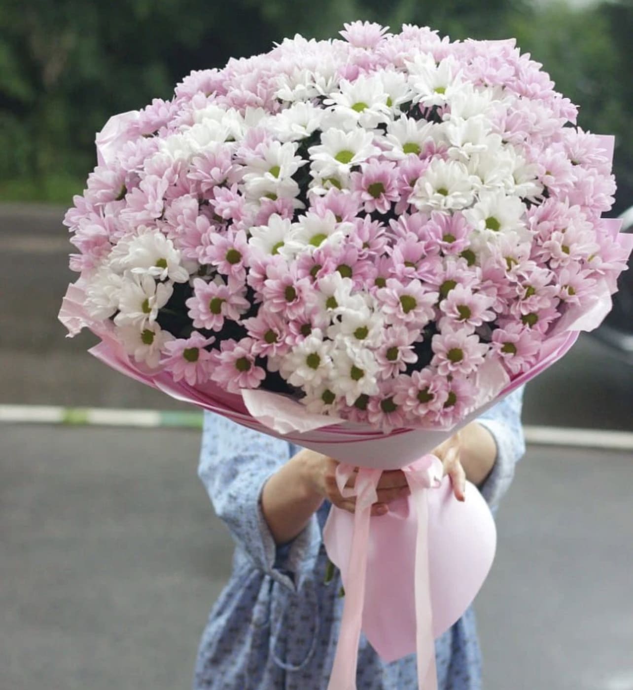 Large bouquet of pink and white daisies wrapped in pink paper