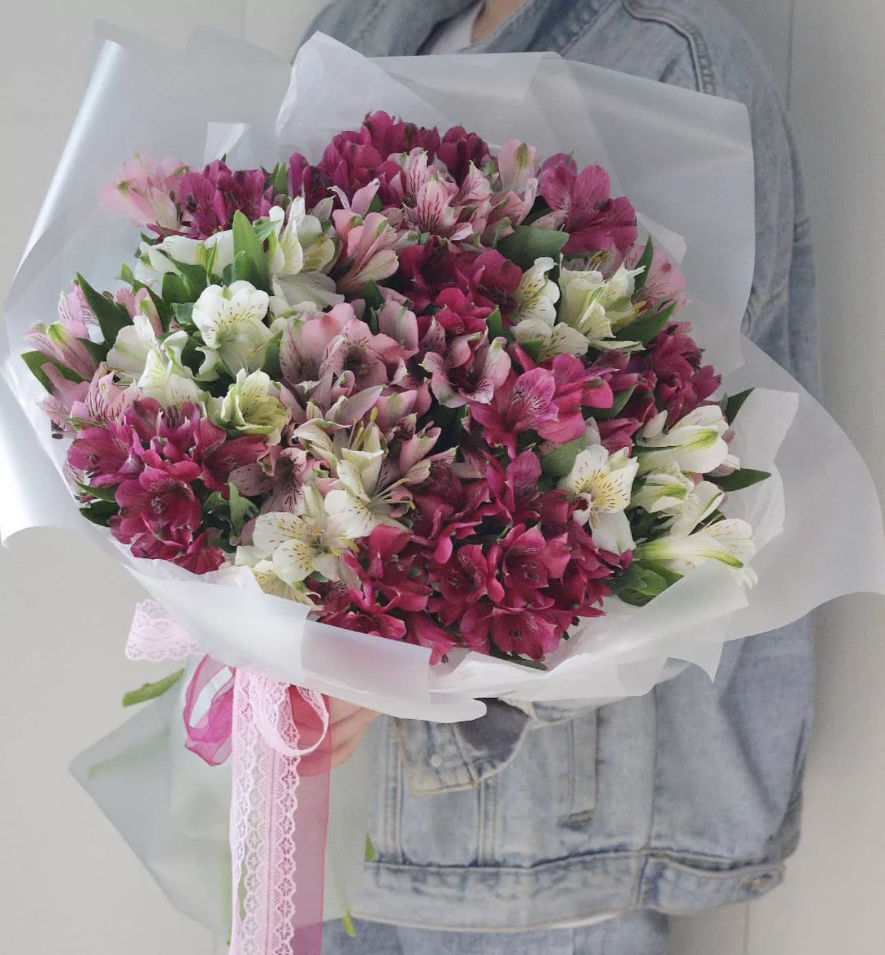 Bouquet of pink, white, and magenta alstroemeria wrapped in white paper