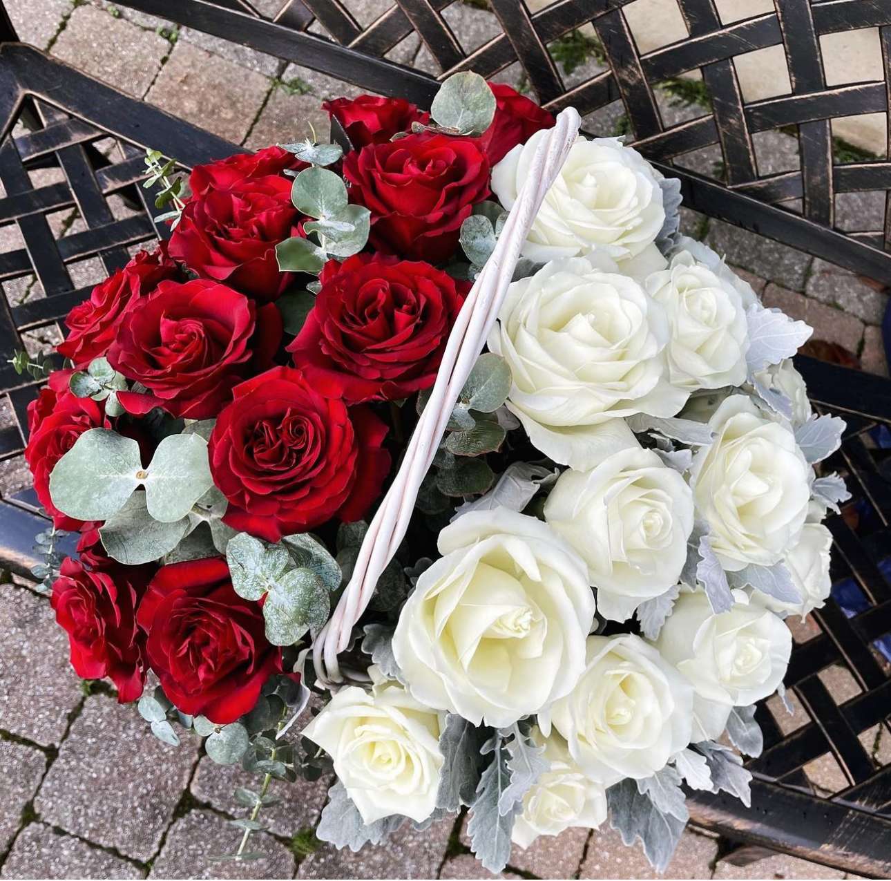 Basket of red and white roses with silver foliage