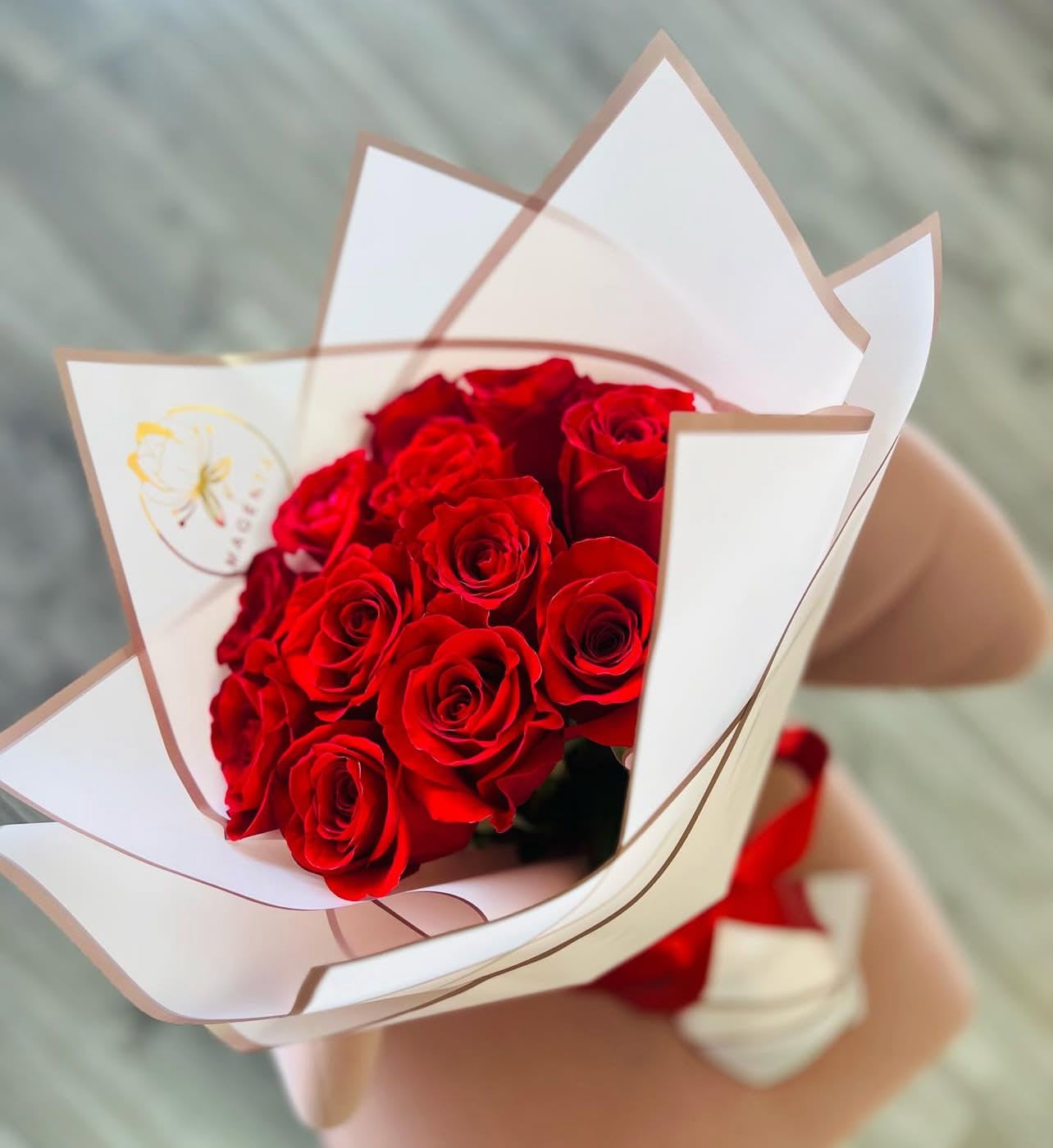 Bouquet of red roses wrapped in white paper
