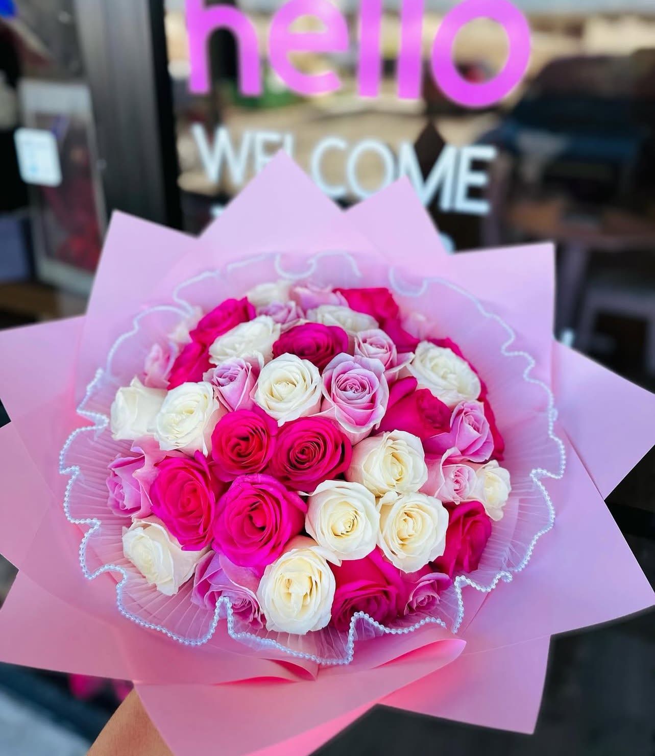 Bouquet of pink and white roses wrapped in pink paper