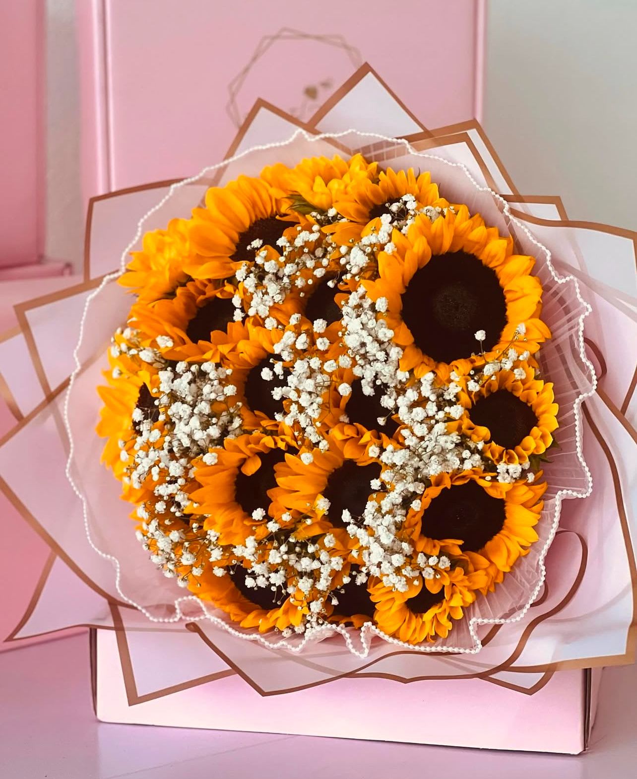 Bouquet of sunflowers with baby's breath in pink wrapping