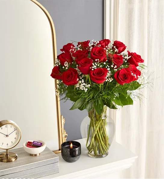 Bouquet of red roses in a clear glass vase with baby's breath